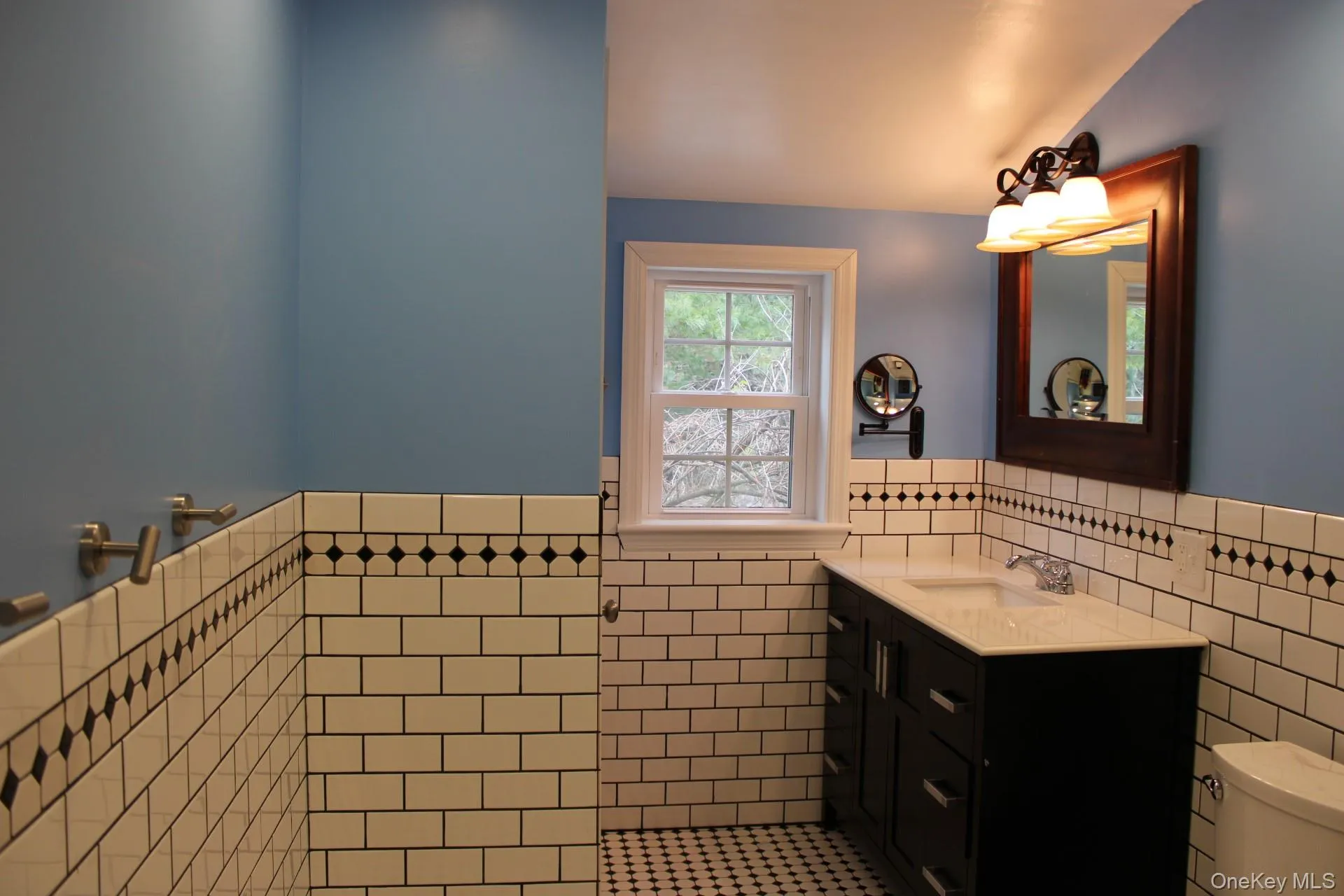Bathroom with tile walls, wainscoting, tile patterned flooring, and vanity Bathroom with tile walls, wainscoting, tile patterned flooring, and vanity