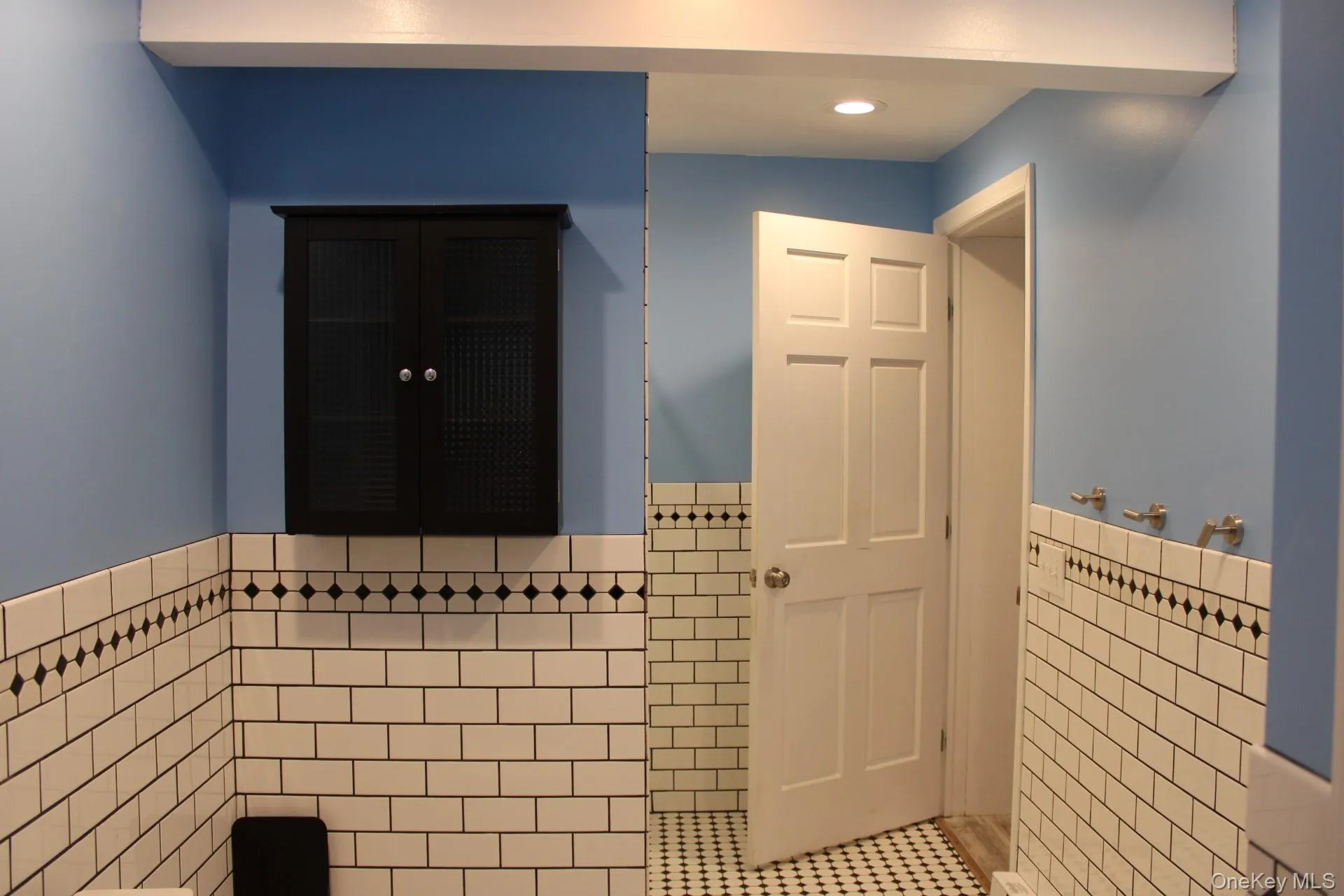 Bathroom featuring tile walls, tile patterned flooring, a wainscoted wall, and recessed lighting Bathroom featuring tile walls, tile patterned flooring, a wainscoted wall, and recessed lighting