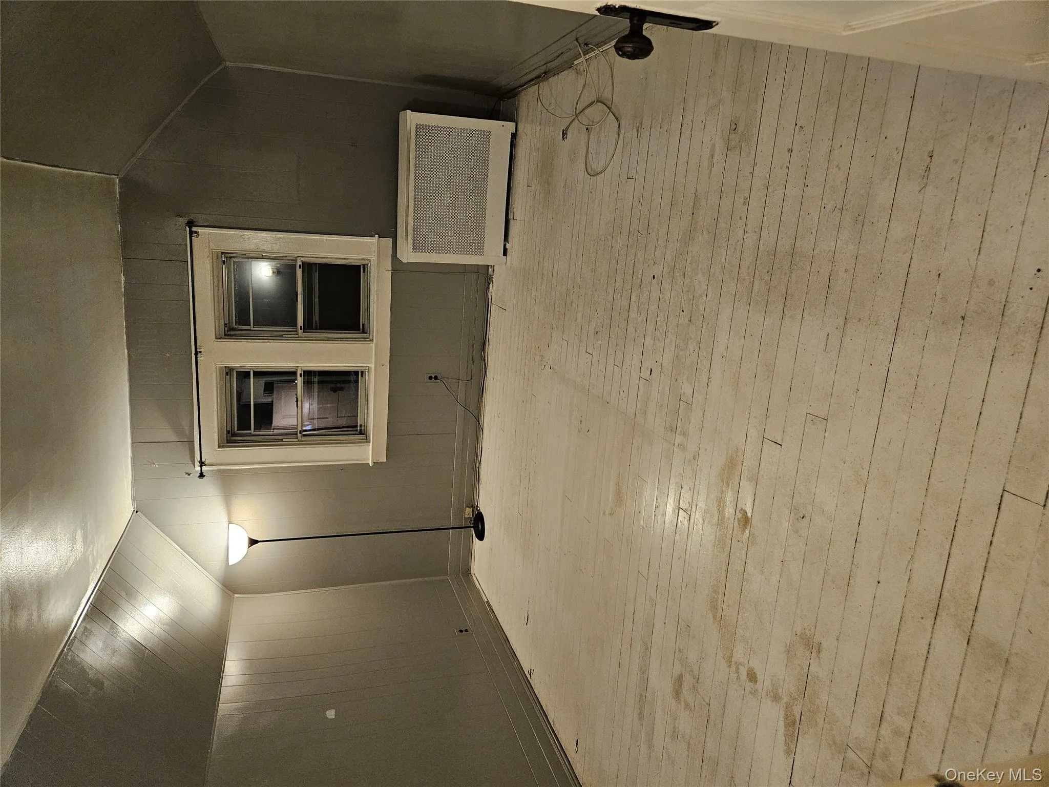 Bonus room with hardwood / wood-style flooring, wood walls, lofted ceiling, and radiator Bonus room with hardwood / wood-style flooring, wood walls, lofted ceiling, and radiator