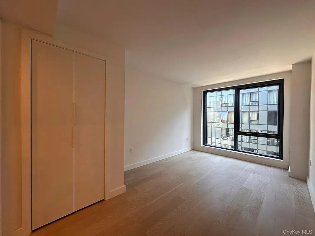 Unfurnished bedroom with light wood finished floors and a closet Unfurnished bedroom with light wood finished floors and a closet