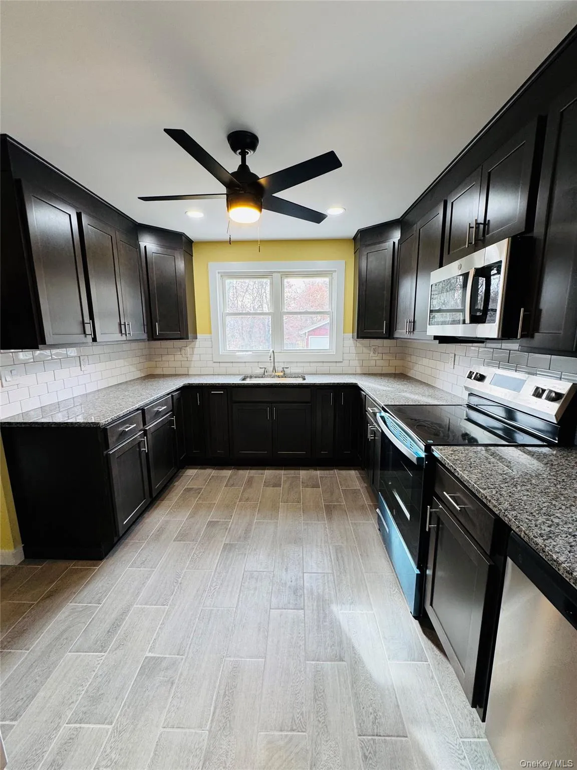 Kitchen featuring appliances with stainless steel finishes, light stone counters, decorative backsplash, ceiling fan, and recessed lighting Kitchen featuring appliances with stainless steel finishes, light stone counters, decorative backsplash, ceiling fan, and recessed lighting