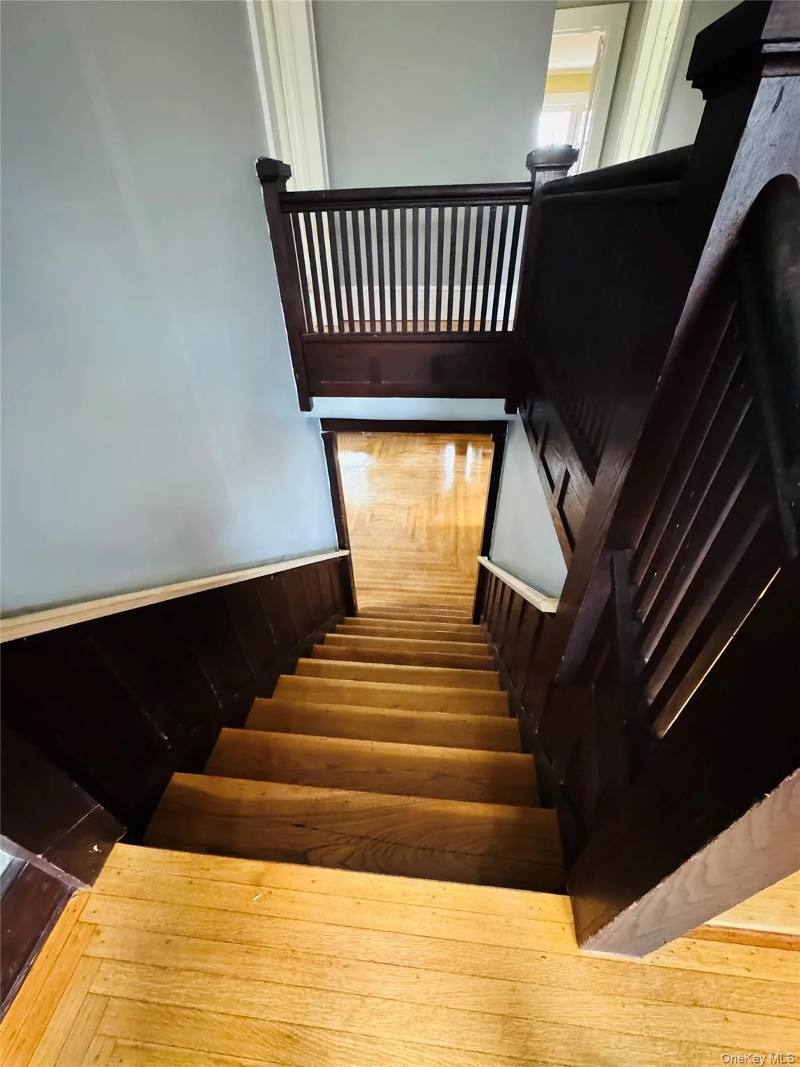 Staircase featuring a wainscoted wall Staircase featuring a wainscoted wall