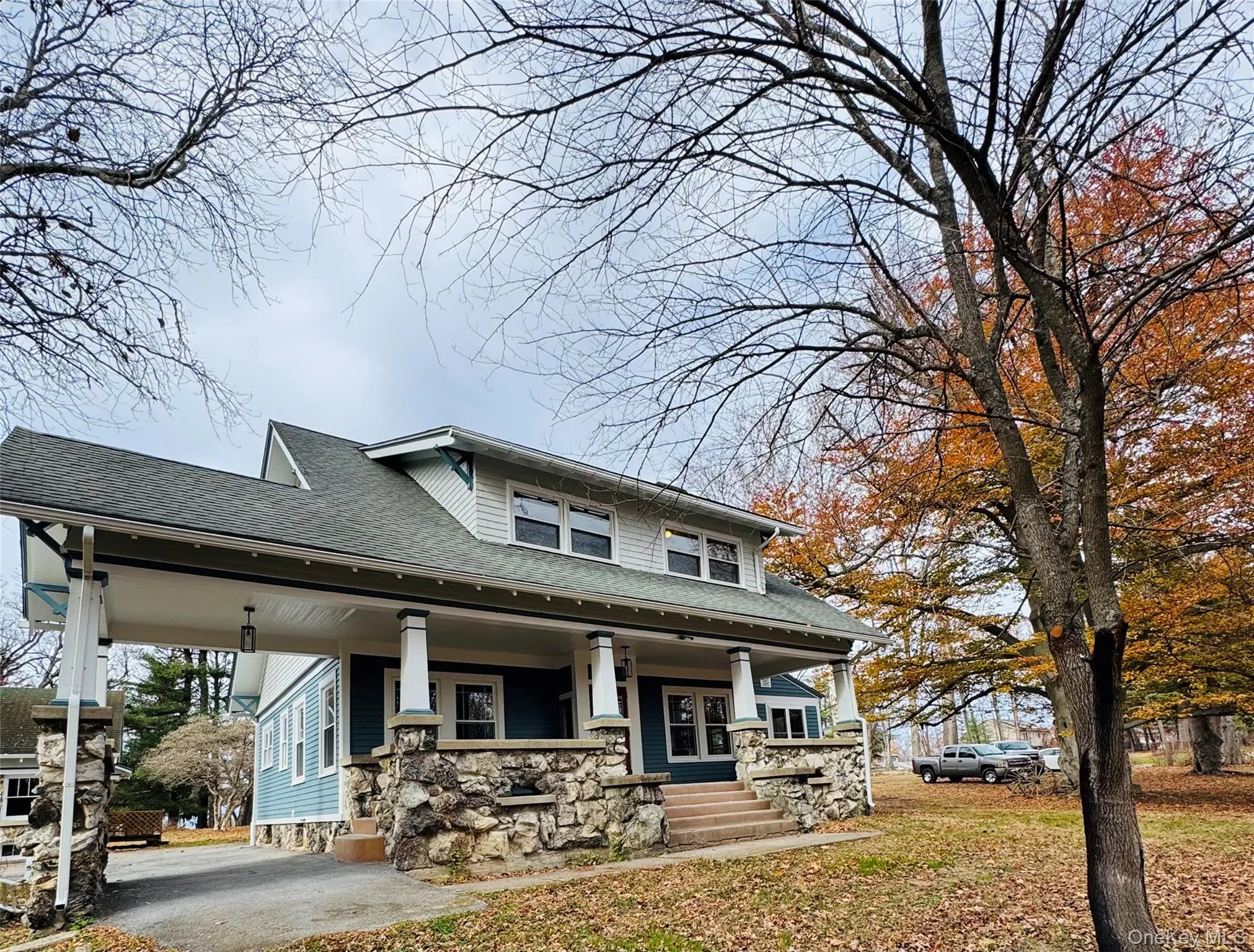 Craftsman-style home featuring a shingled roof, a porch, and a front yard Craftsman-style home featuring a shingled roof, a porch, and a front yard