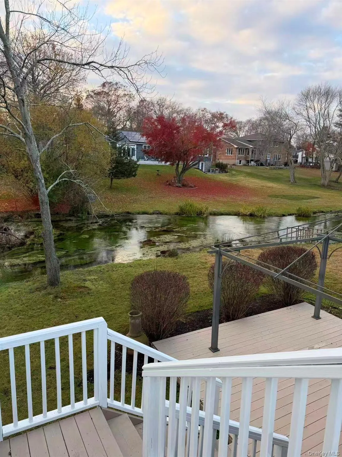 View of green lawn with a deck with water view View of green lawn with a deck with water view