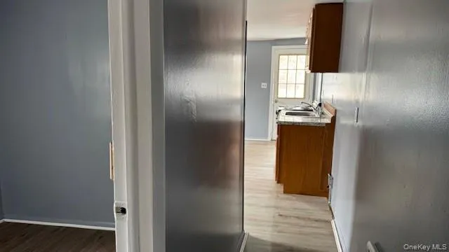 Hallway with light wood-style flooring and baseboards Hallway with light wood-style flooring and baseboards