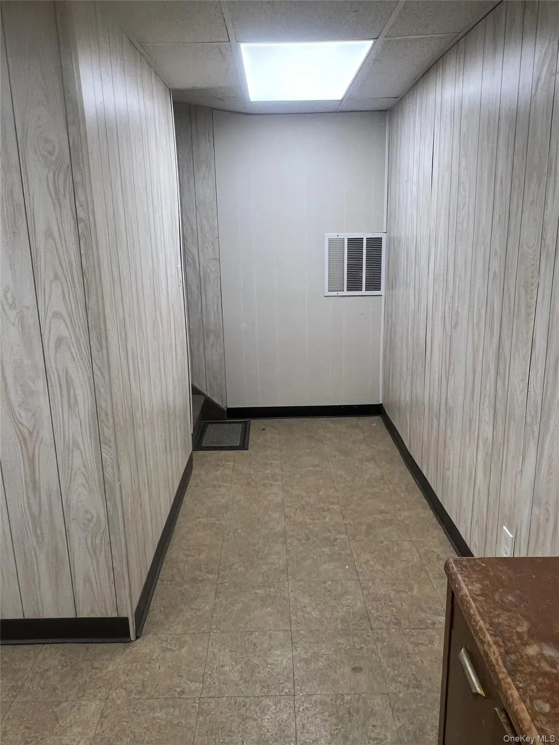 Empty room featuring a paneled ceiling and wooden walls Empty room featuring a paneled ceiling and wooden walls
