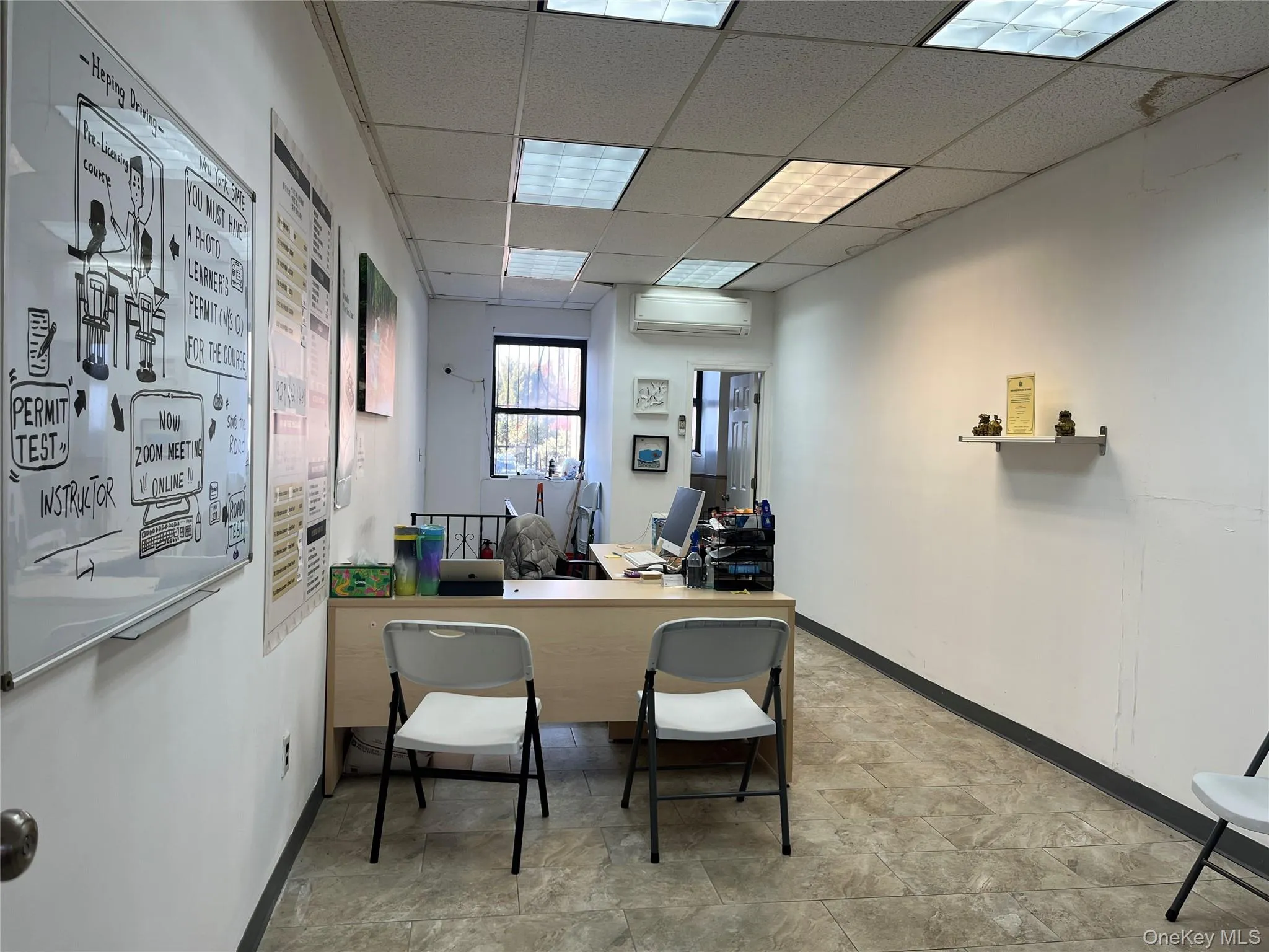 Office area featuring a drop ceiling and a wall mounted air conditioner Office area featuring a drop ceiling and a wall mounted air conditioner