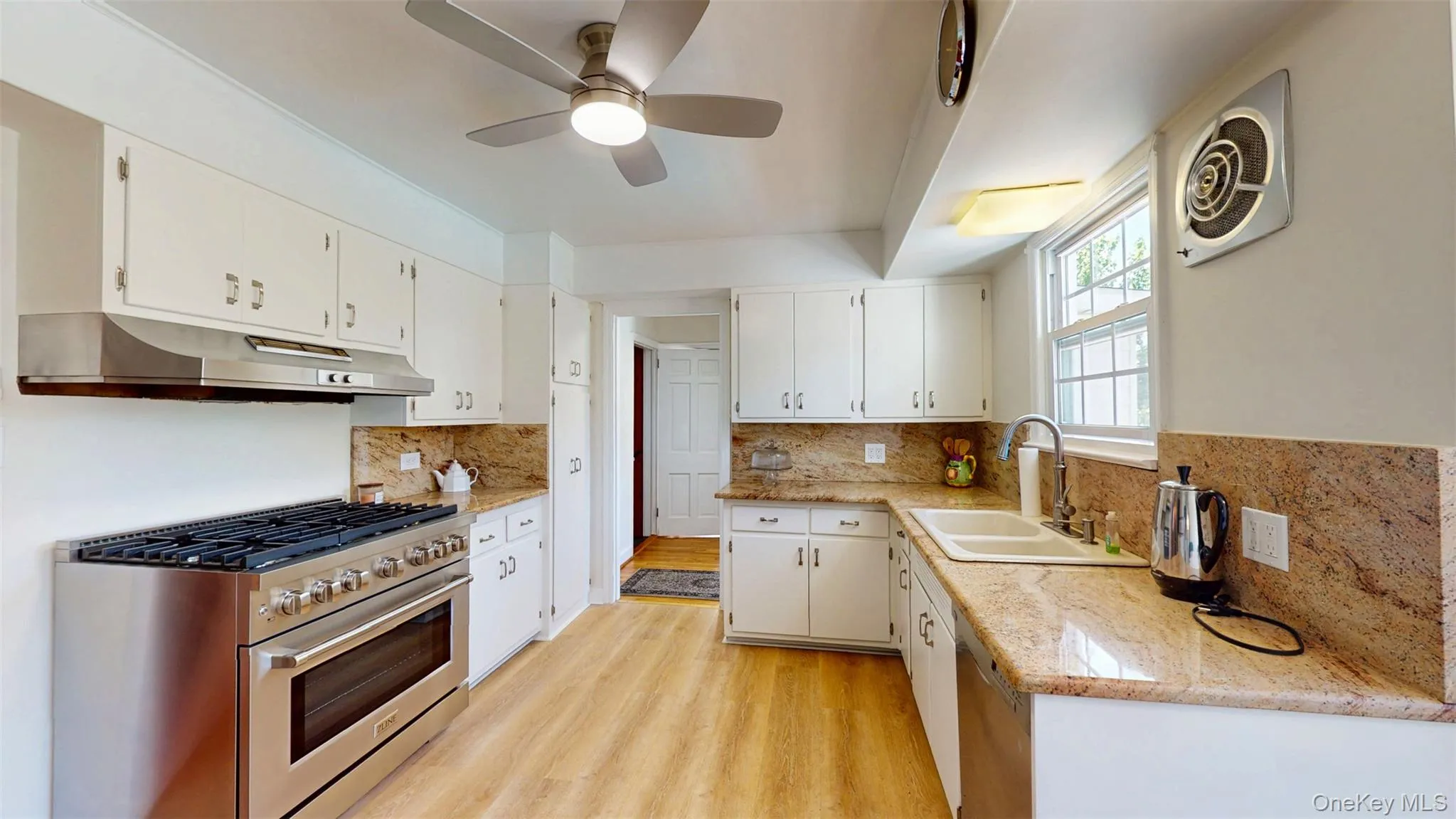 Kitchen with NEW high end GAS stainless steel range oven, under cabinet range hood, white cabinetry, and NEW ceiling fan Kitchen with NEW high end GAS stainless steel range oven, under cabinet range hood, white cabinetry, and NEW ceiling fan