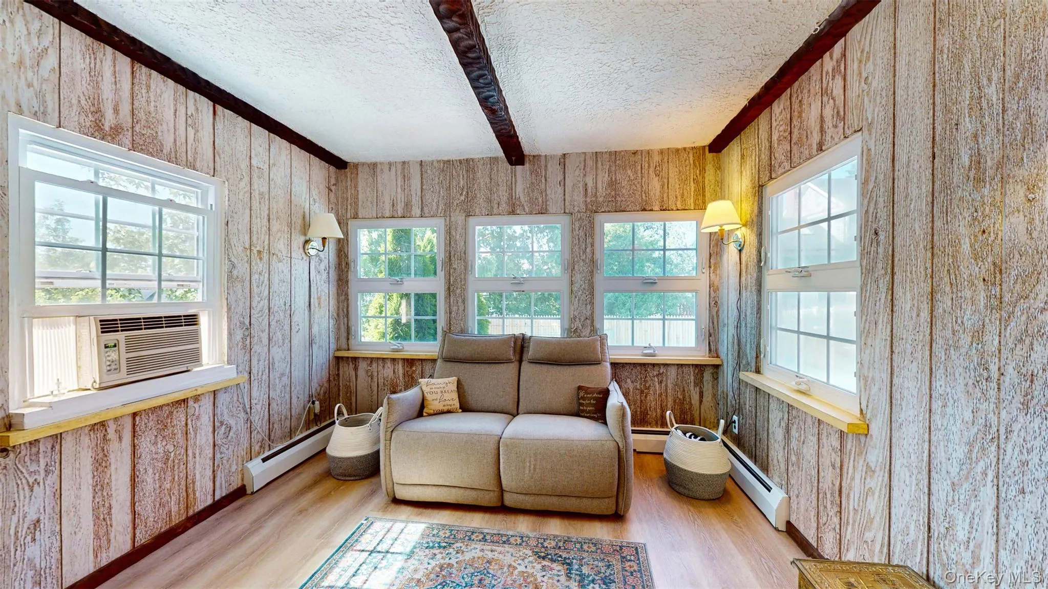 Sunroom with a baseboard radiator, beamed ceiling, and cooling unit Sunroom with a baseboard radiator, beamed ceiling, and cooling unit