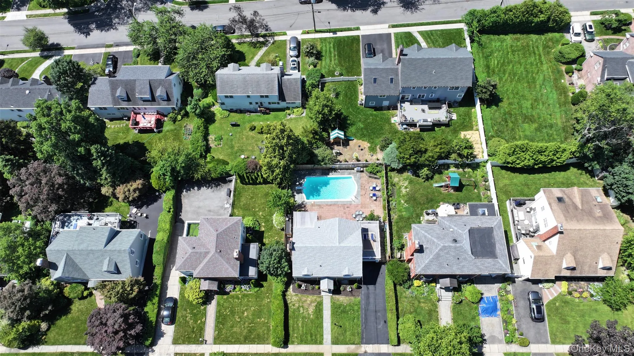 Aerial view of property's location with nearby suburban area and a pool area Aerial view of property's location with nearby suburban area and a pool area