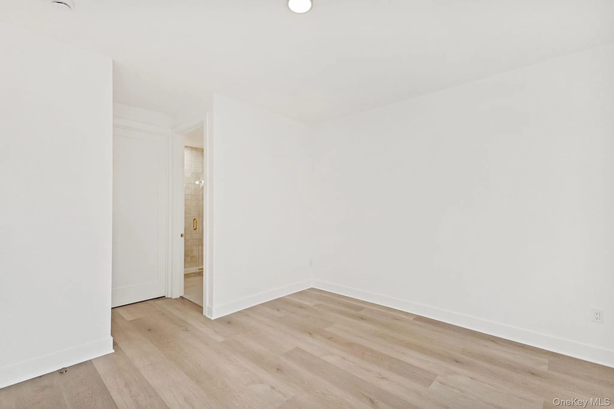 Unfurnished room with light wood finished floors and baseboards Unfurnished room with light wood finished floors and baseboards