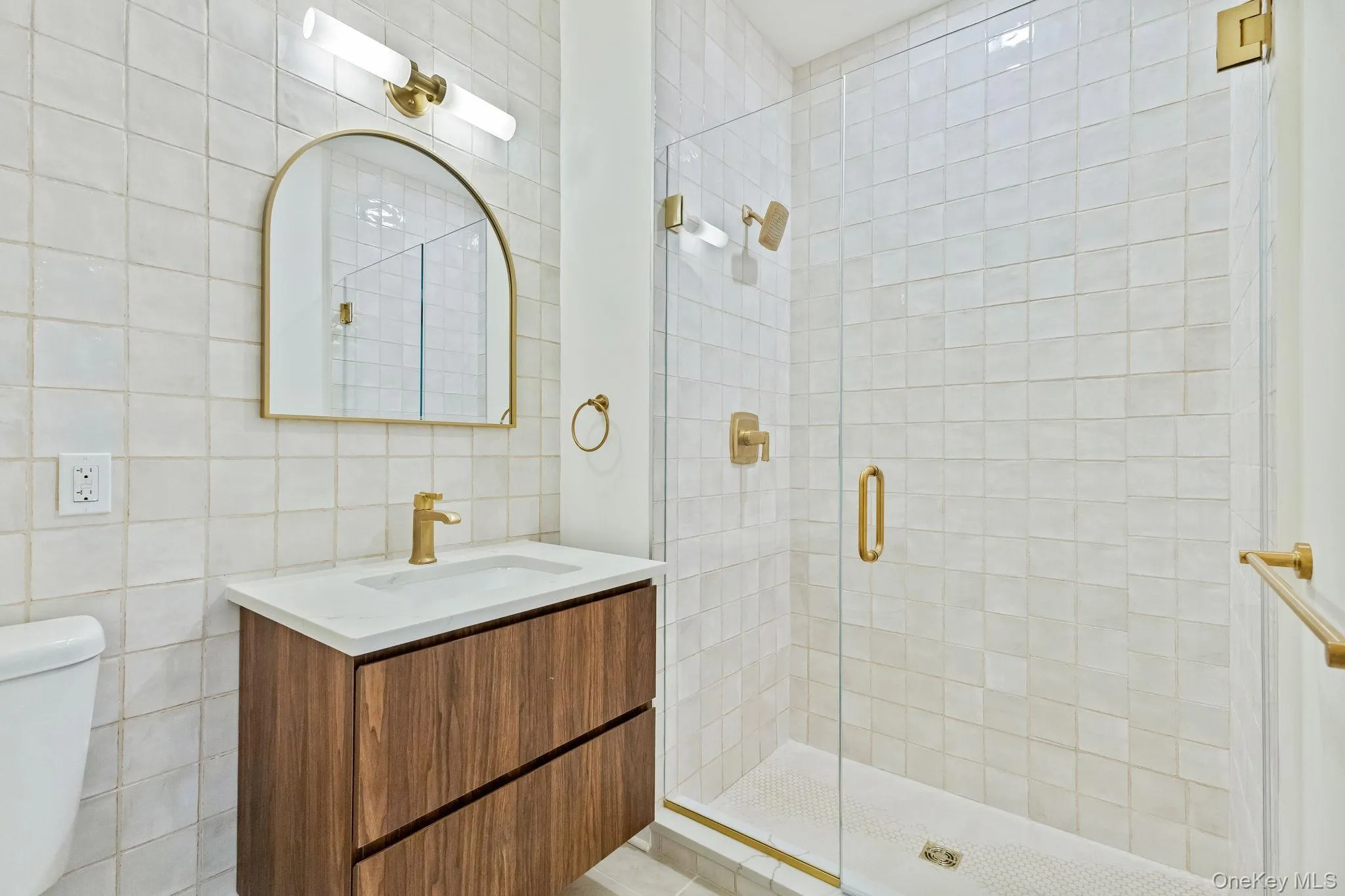 Bathroom featuring tile walls, vanity, and a stall shower Bathroom featuring tile walls, vanity, and a stall shower