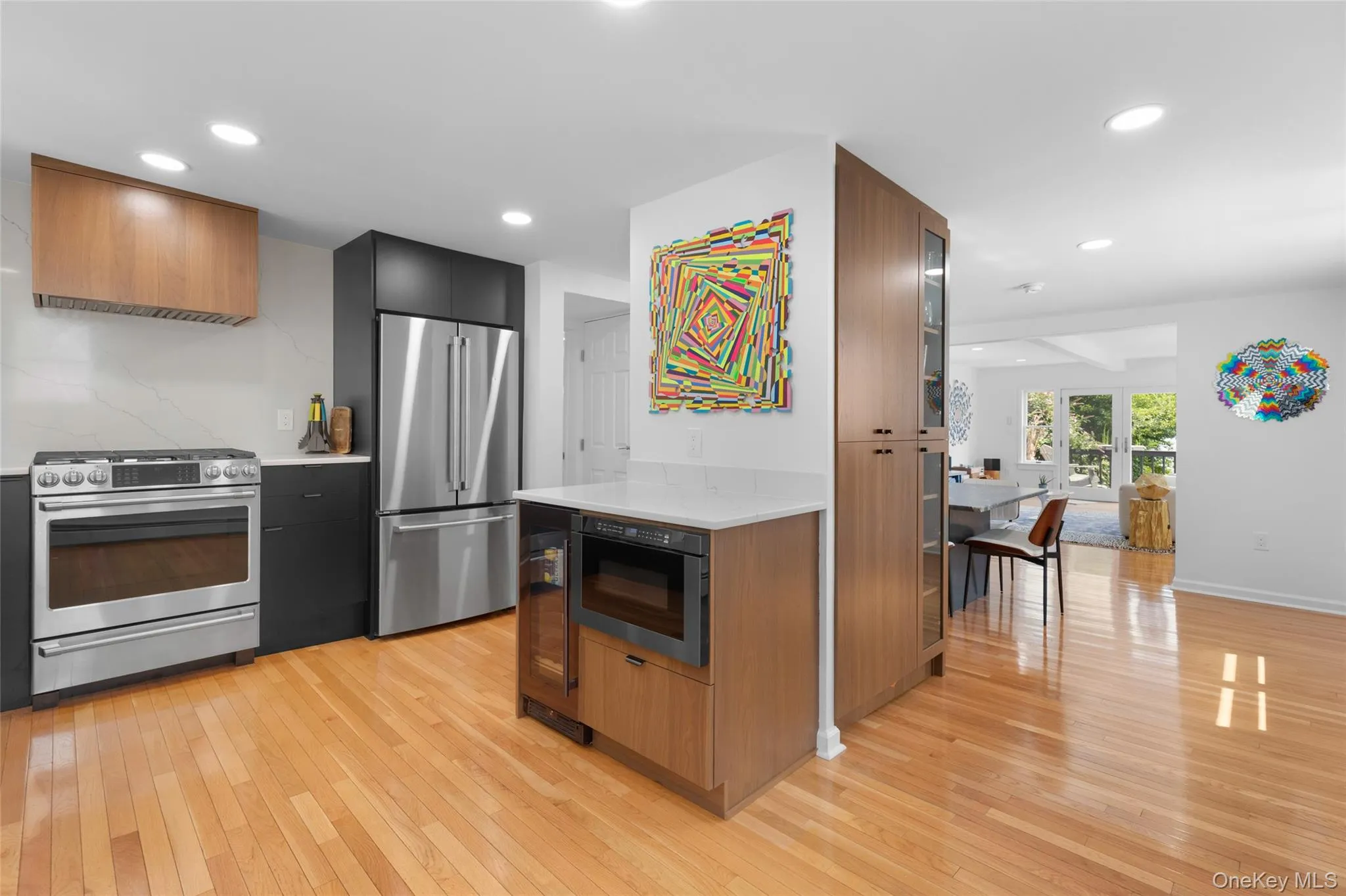 Kitchen featuring stainless steel appliances, light wood finished floors, recessed lighting, light stone countertops, and modern cabinets Kitchen featuring stainless steel appliances, light wood finished floors, recessed lighting, light stone countertops, and modern cabinets