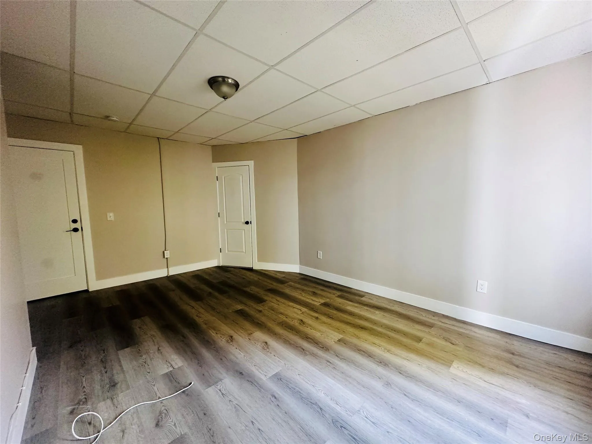Spare room featuring a paneled ceiling and wood finished floors Spare room featuring a paneled ceiling and wood finished floors