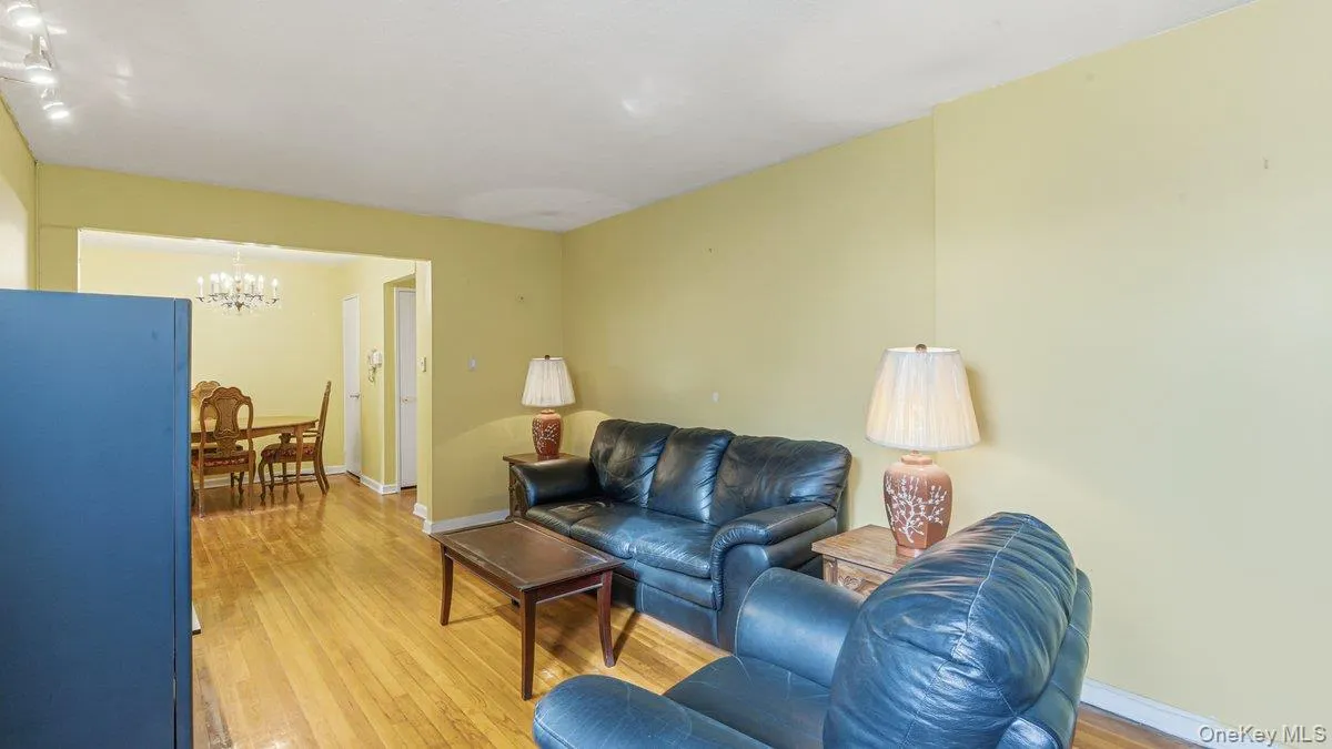 Living room with light wood-style flooring and a chandelier Living room with light wood-style flooring and a chandelier