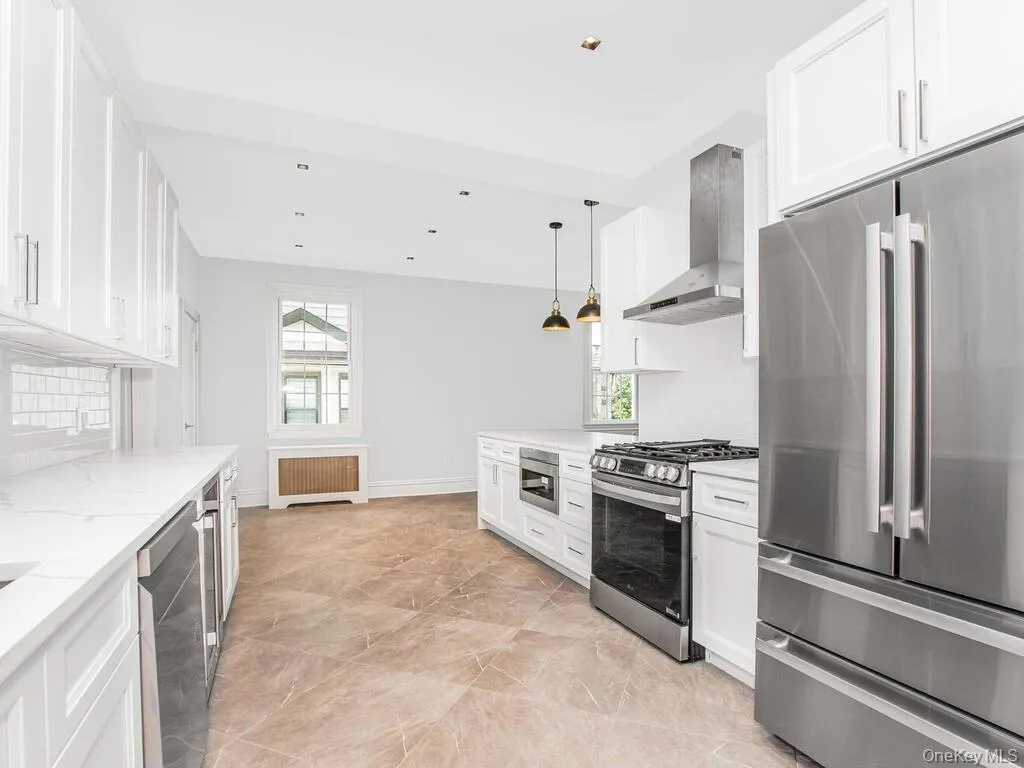Kitchen with stainless steel appliances, decorative backsplash, wall chimney exhaust hood, plenty of natural light, and recessed lighting Kitchen with stainless steel appliances, decorative backsplash, wall chimney exhaust hood, plenty of natural light, and recessed lighting