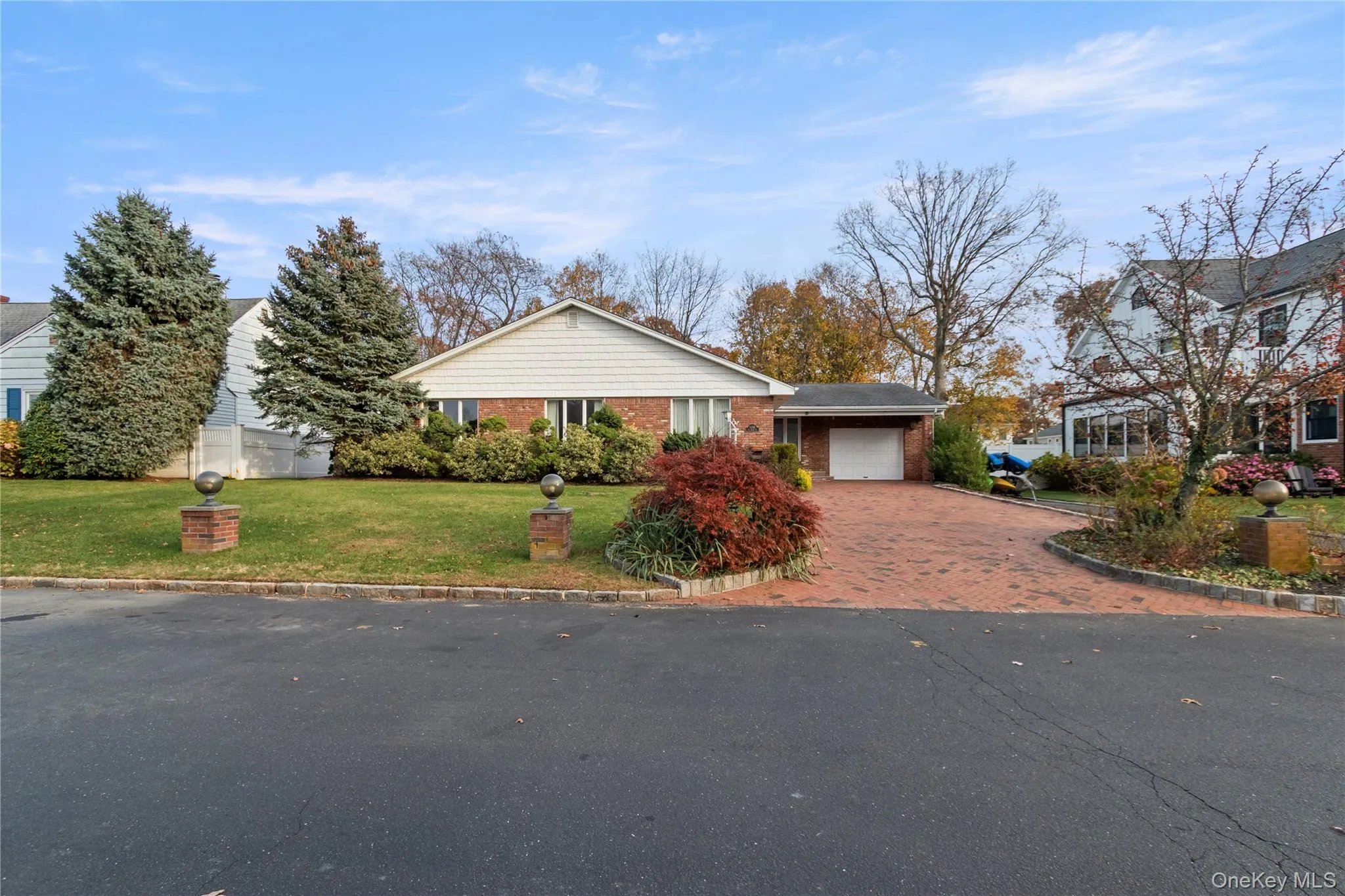 View of front of home with a front yard, decorative driveway, and brick siding View of front of home with a front yard, decorative driveway, and brick siding