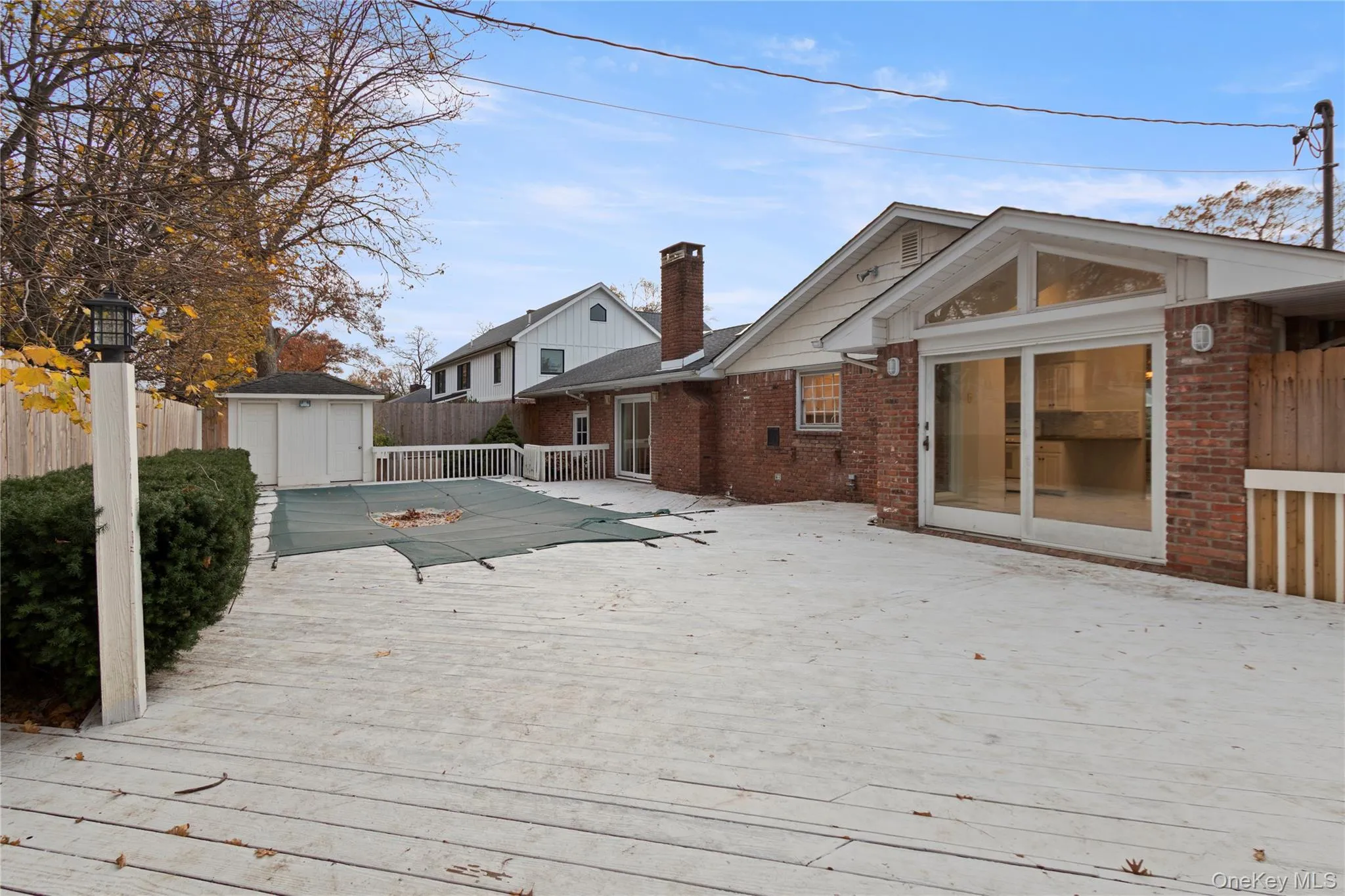Wooden terrace featuring a storage unit and a fenced backyard Wooden terrace featuring a storage unit and a fenced backyard