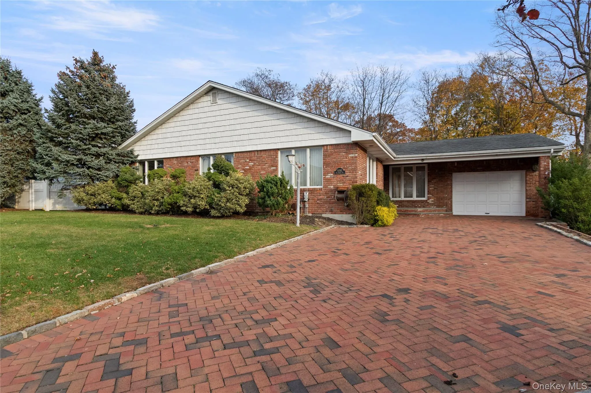 Ranch-style home with an attached garage, a front yard, brick siding, and decorative driveway Ranch-style home with an attached garage, a front yard, brick siding, and decorative driveway