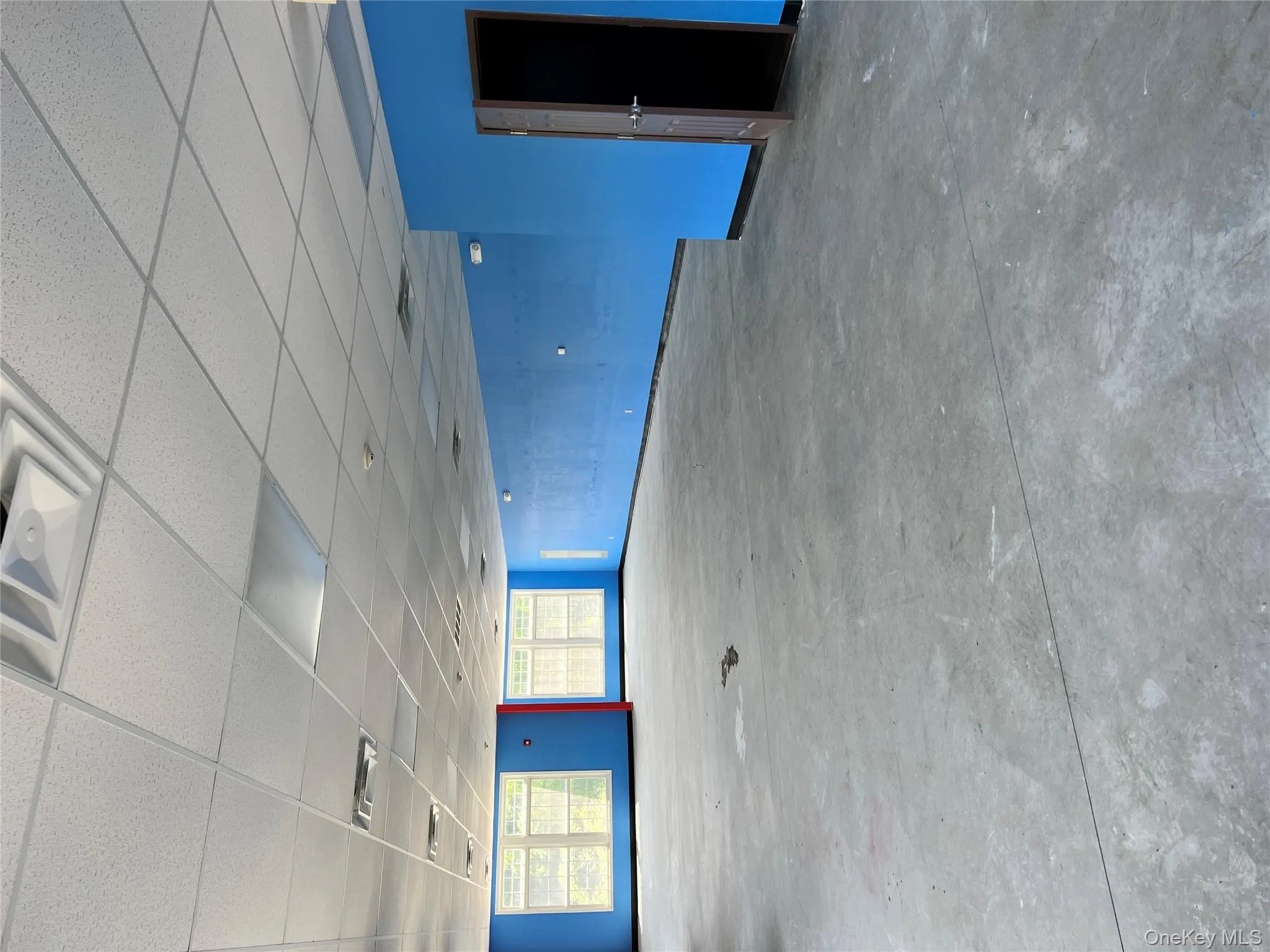 Unfurnished room featuring concrete floors and a drop ceiling Unfurnished room featuring concrete floors and a drop ceiling