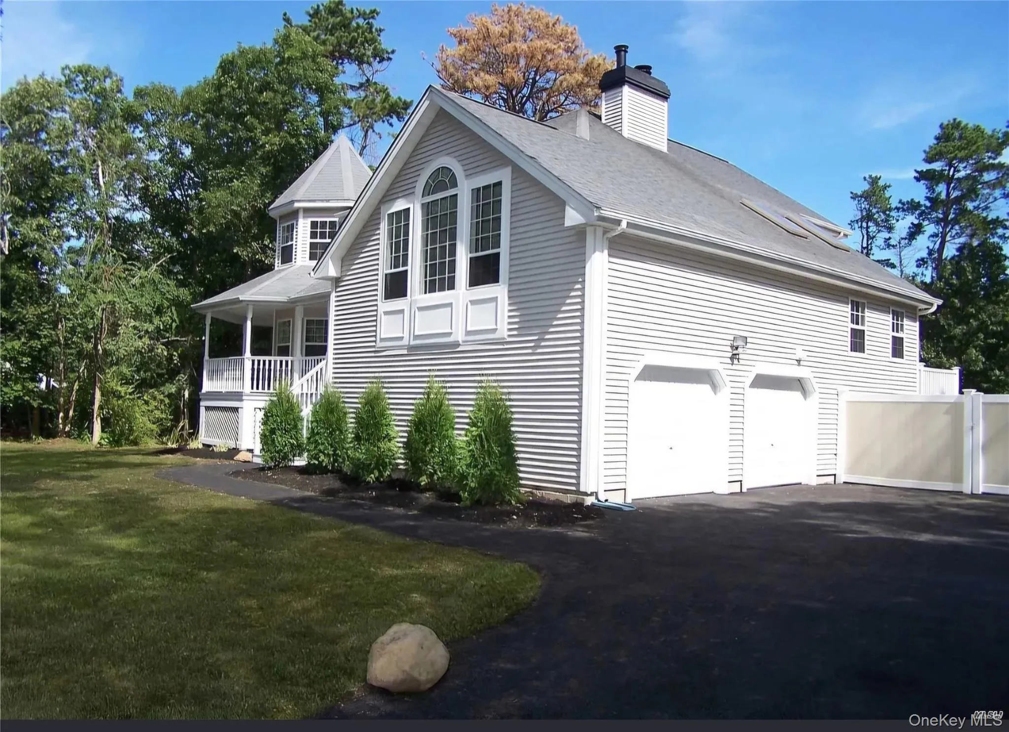 View of home's exterior with a porch, driveway, a lawn, a chimney, and an attached garage View of home's exterior with a porch, driveway, a lawn, a chimney, and an attached garage