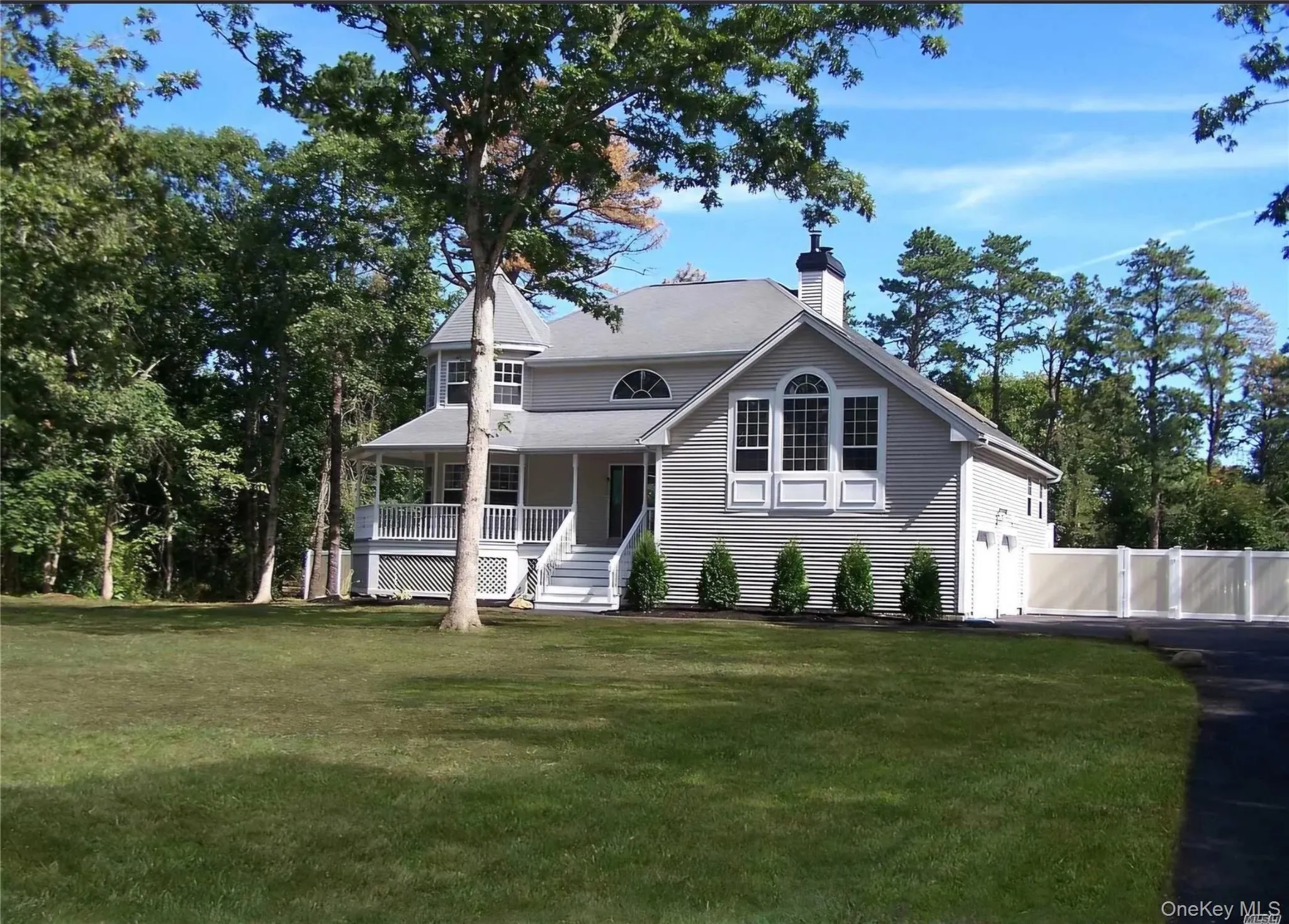 View of front of home with a porch, a chimney, a garage, and stairway View of front of home with a porch, a chimney, a garage, and stairway