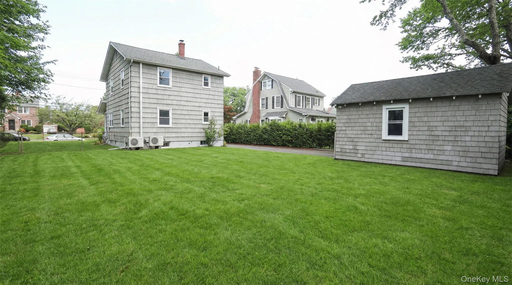 Rear view of property with a yard, a chimney, and roof with shingles Rear view of property with a yard, a chimney, and roof with shingles