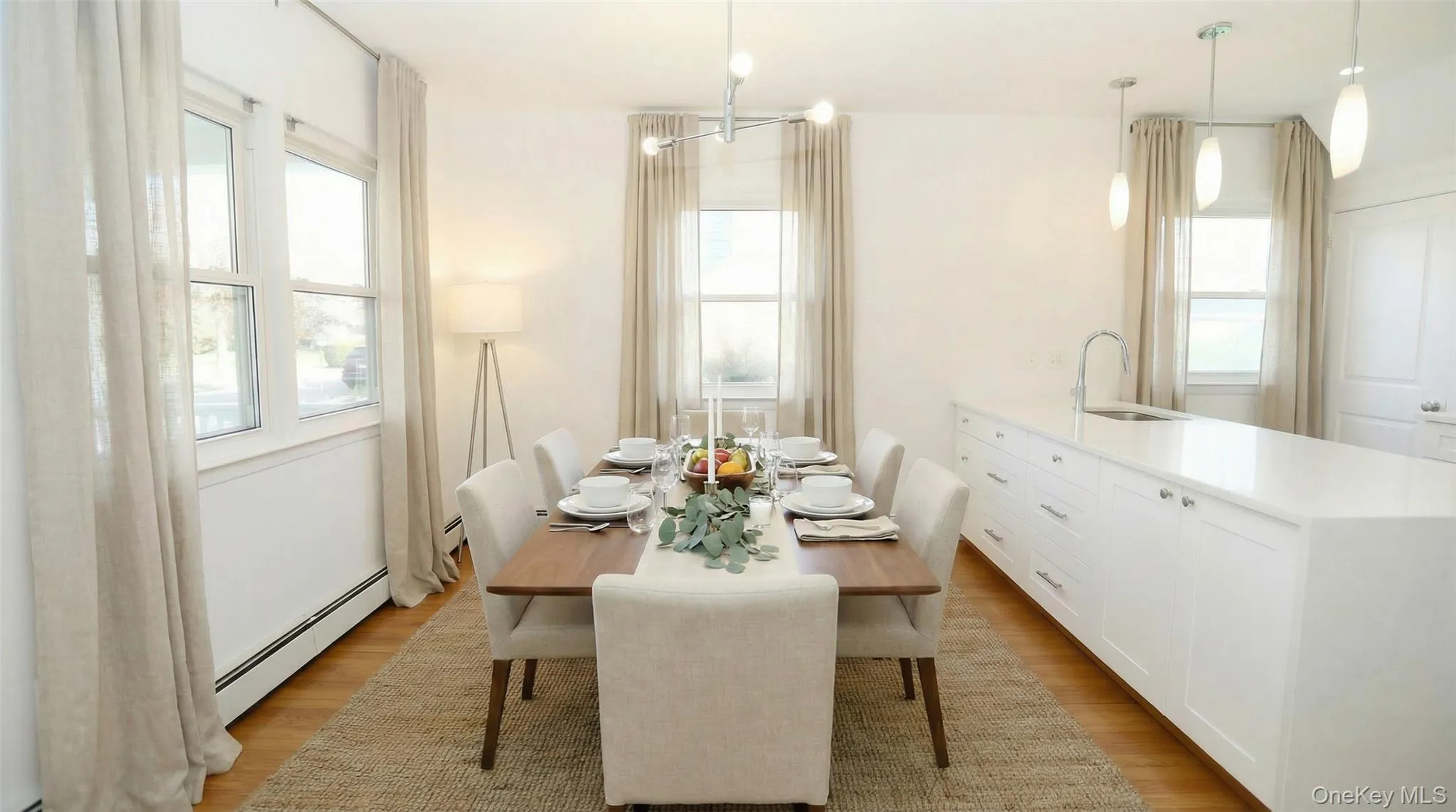 Dining area with baseboard heating, light wood-type flooring, plenty of natural light, and a chandelier Dining area with baseboard heating, light wood-type flooring, plenty of natural light, and a chandelier