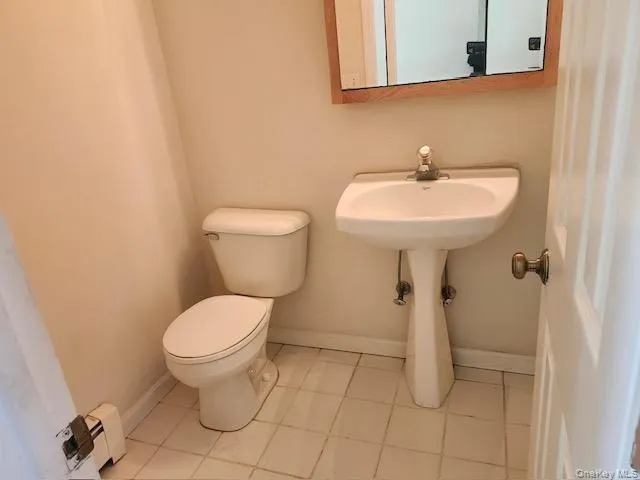 Bathroom with light tile patterned flooring and baseboard heating Bathroom with light tile patterned flooring and baseboard heating