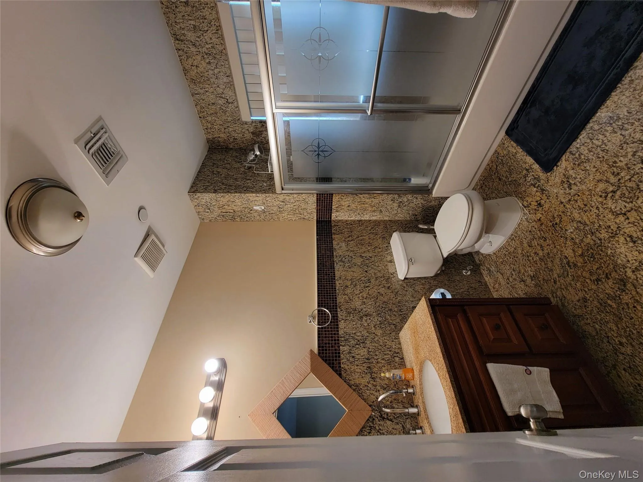 Full bath featuring tile walls, vanity, combined bath / shower with glass door, and wainscoting Full bath featuring tile walls, vanity, combined bath / shower with glass door, and wainscoting