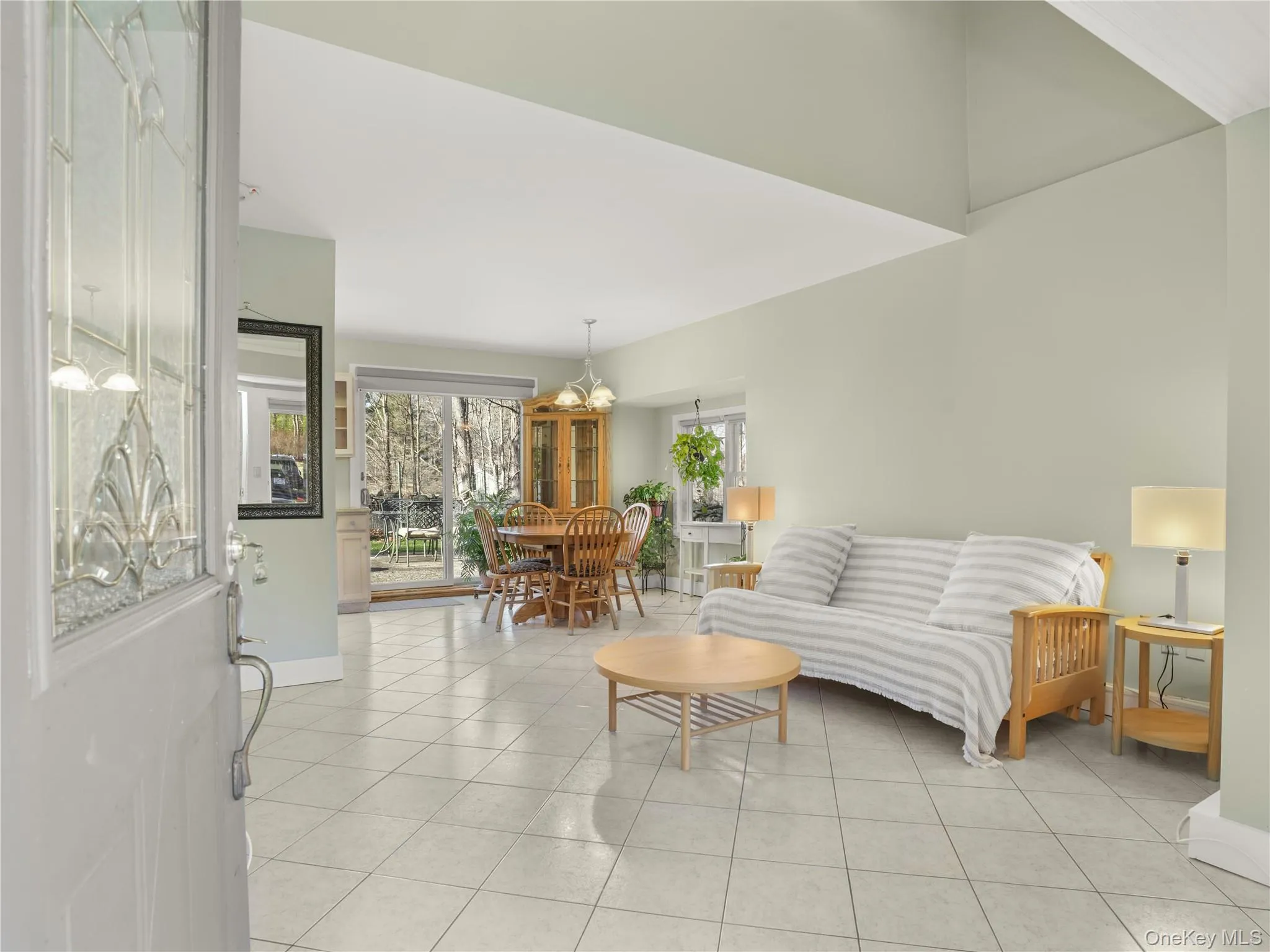 Living room featuring light tile patterned flooring and a chandelier Living room featuring light tile patterned flooring and a chandelier