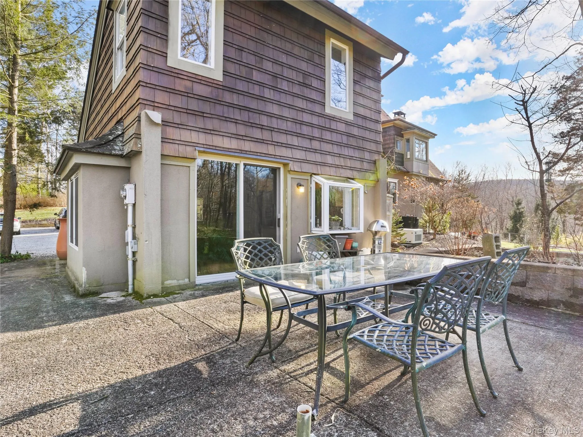 Rear view of house with a patio, outdoor dining space, and stucco siding Rear view of house with a patio, outdoor dining space, and stucco siding