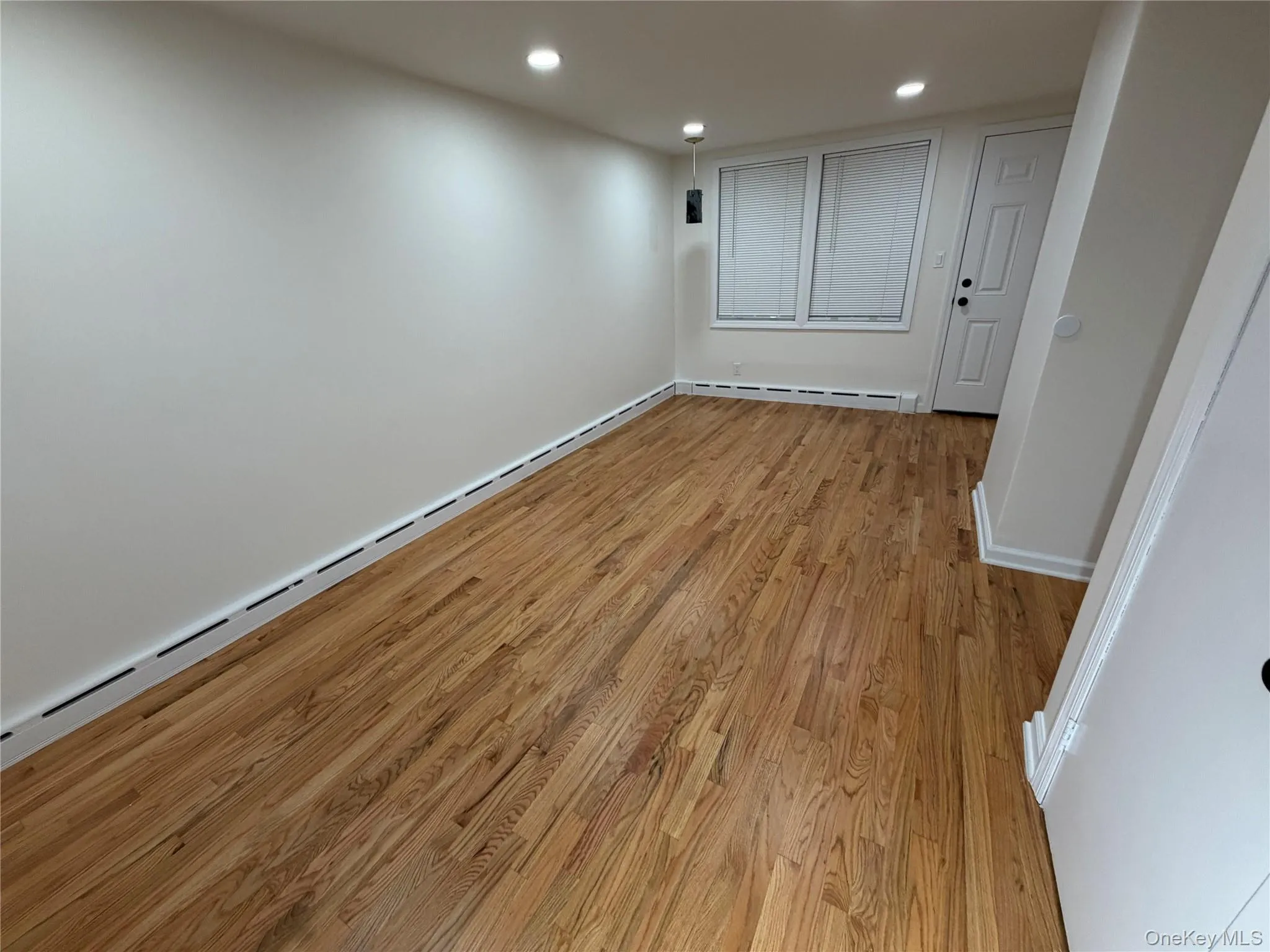 Spare room featuring baseboard heating, light wood-style floors, and recessed lighting Spare room featuring baseboard heating, light wood-style floors, and recessed lighting