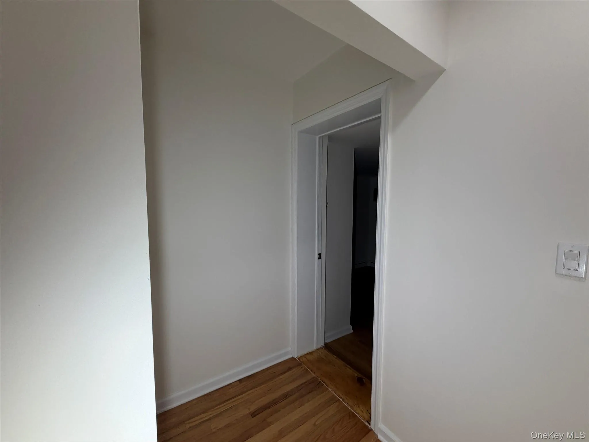 Hall with light wood-style flooring and baseboards Hall with light wood-style flooring and baseboards