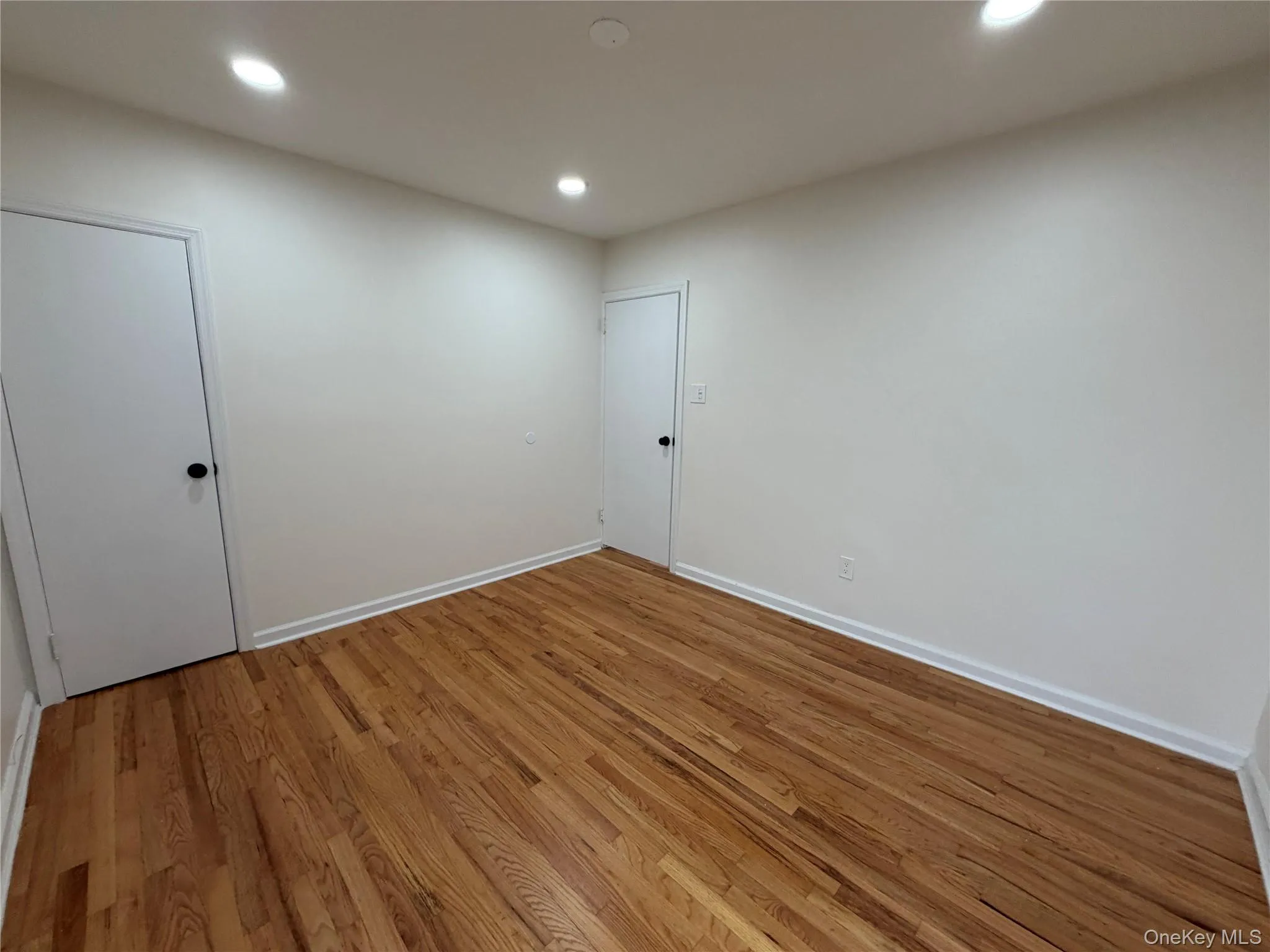 Unfurnished room with wood finished floors and recessed lighting Unfurnished room with wood finished floors and recessed lighting