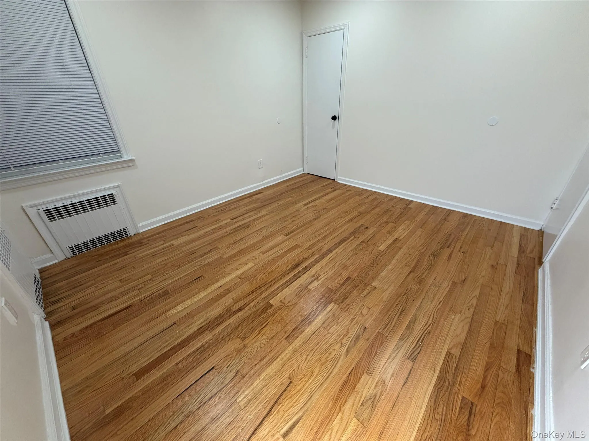 Spare room with light wood-type flooring and a wall unit AC Spare room with light wood-type flooring and a wall unit AC