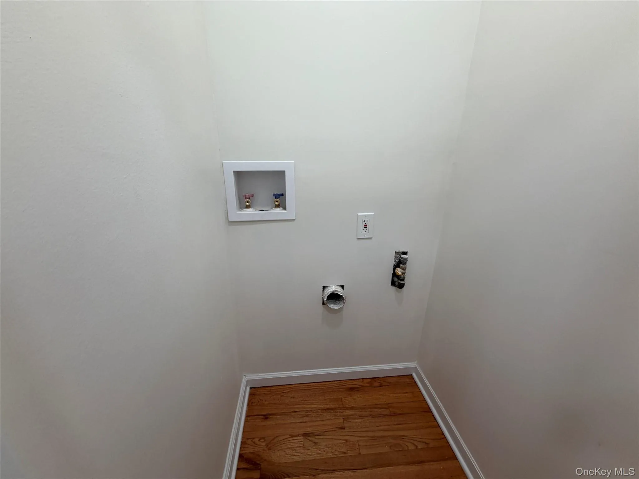 Washroom featuring wood finished floors and washer hookup Washroom featuring wood finished floors and washer hookup