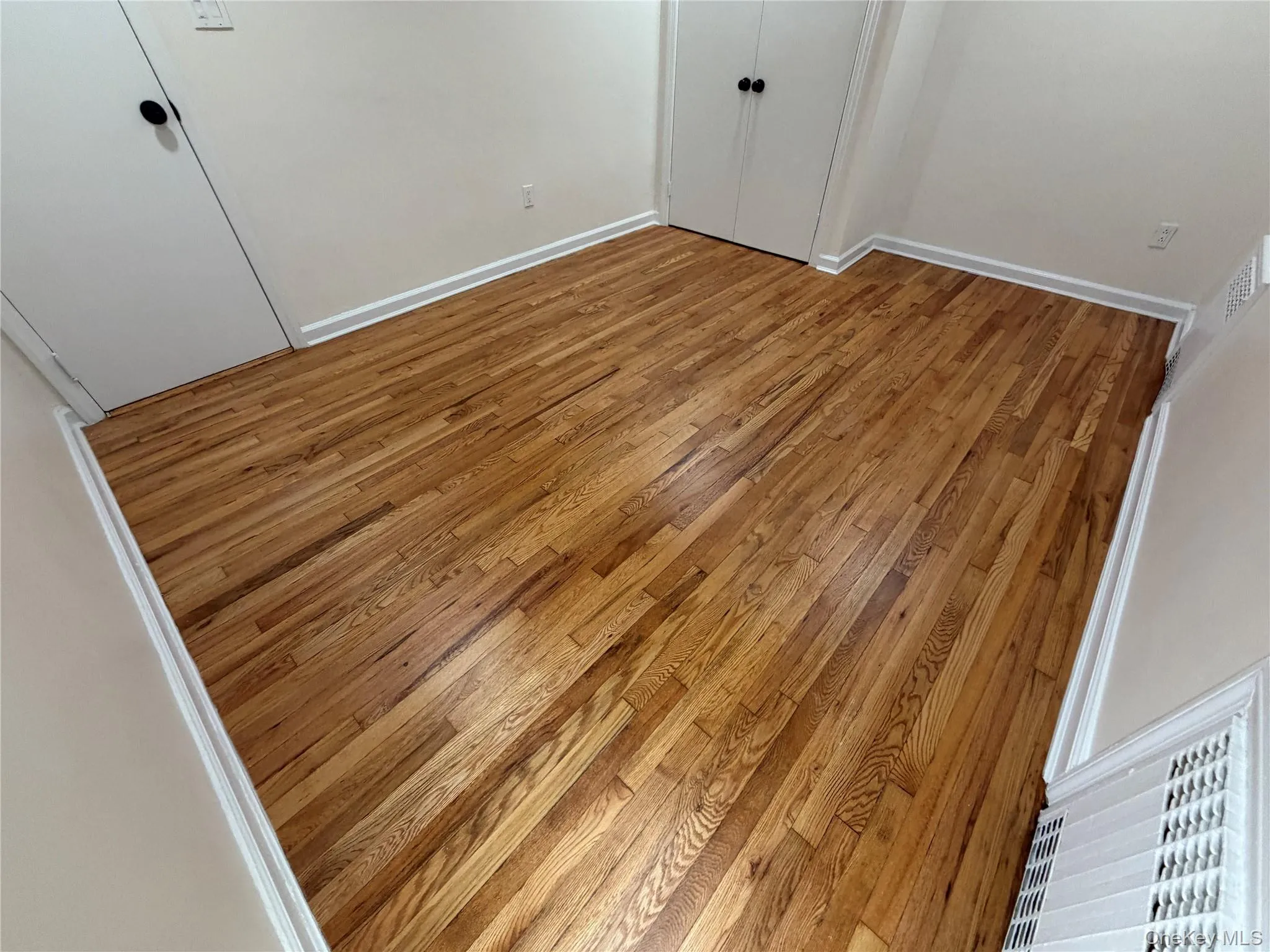 Unfurnished bedroom featuring wood-type flooring and a closet Unfurnished bedroom featuring wood-type flooring and a closet