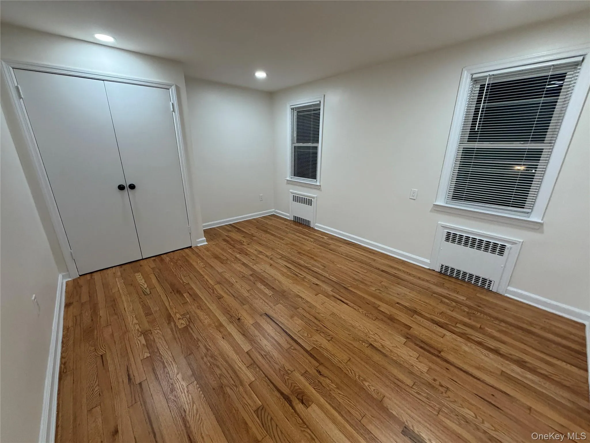 Unfurnished bedroom featuring light wood-type flooring, a closet, recessed lighting, and radiator Unfurnished bedroom featuring light wood-type flooring, a closet, recessed lighting, and radiator