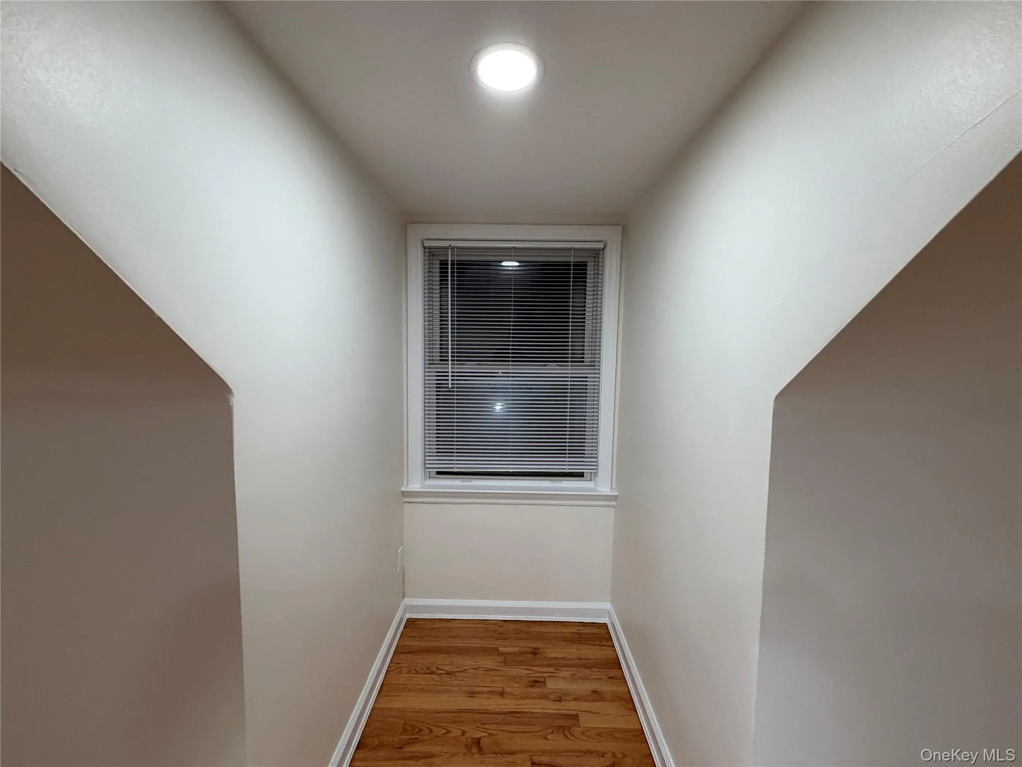 Hall with baseboards and light wood-style flooring Hall with baseboards and light wood-style flooring