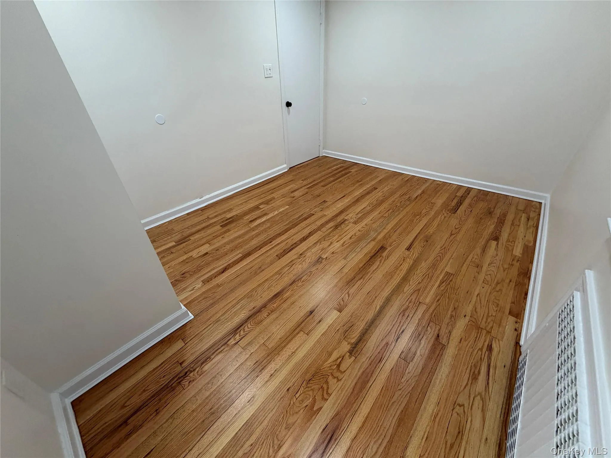 Unfurnished room featuring hardwood / wood-style flooring and baseboards Unfurnished room featuring hardwood / wood-style flooring and baseboards
