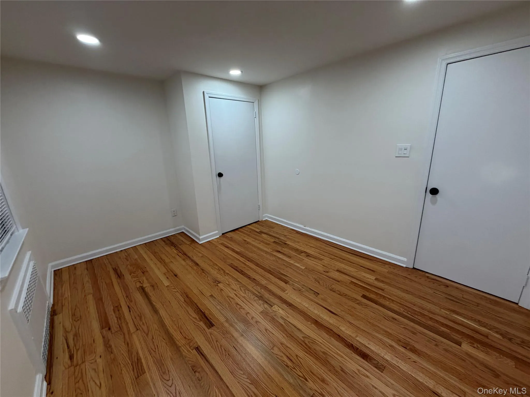 Empty room with light wood-style floors and recessed lighting Empty room with light wood-style floors and recessed lighting