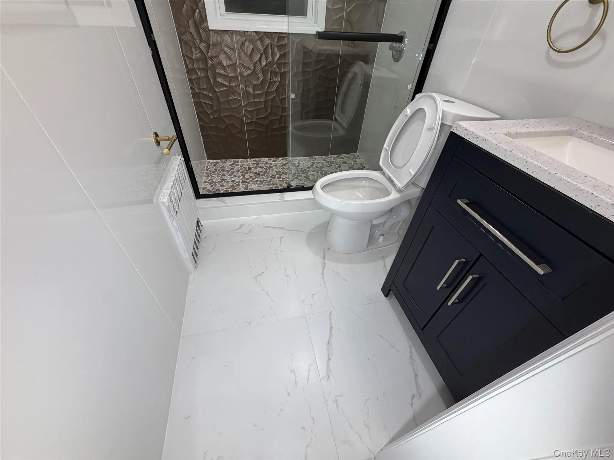 Full bathroom with vanity, a shower stall, and marble look tile flooring Full bathroom with vanity, a shower stall, and marble look tile flooring