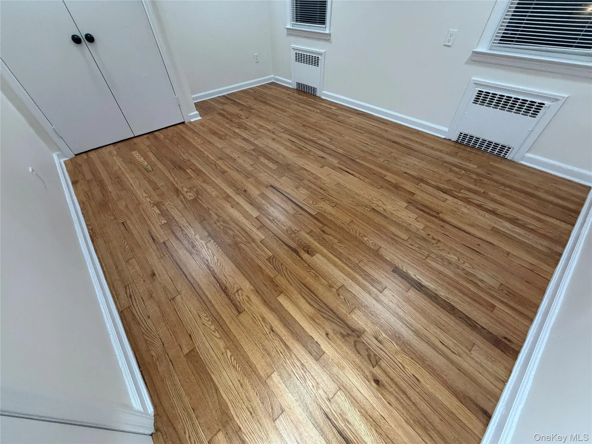 Empty room featuring light wood-type flooring and radiator Empty room featuring light wood-type flooring and radiator