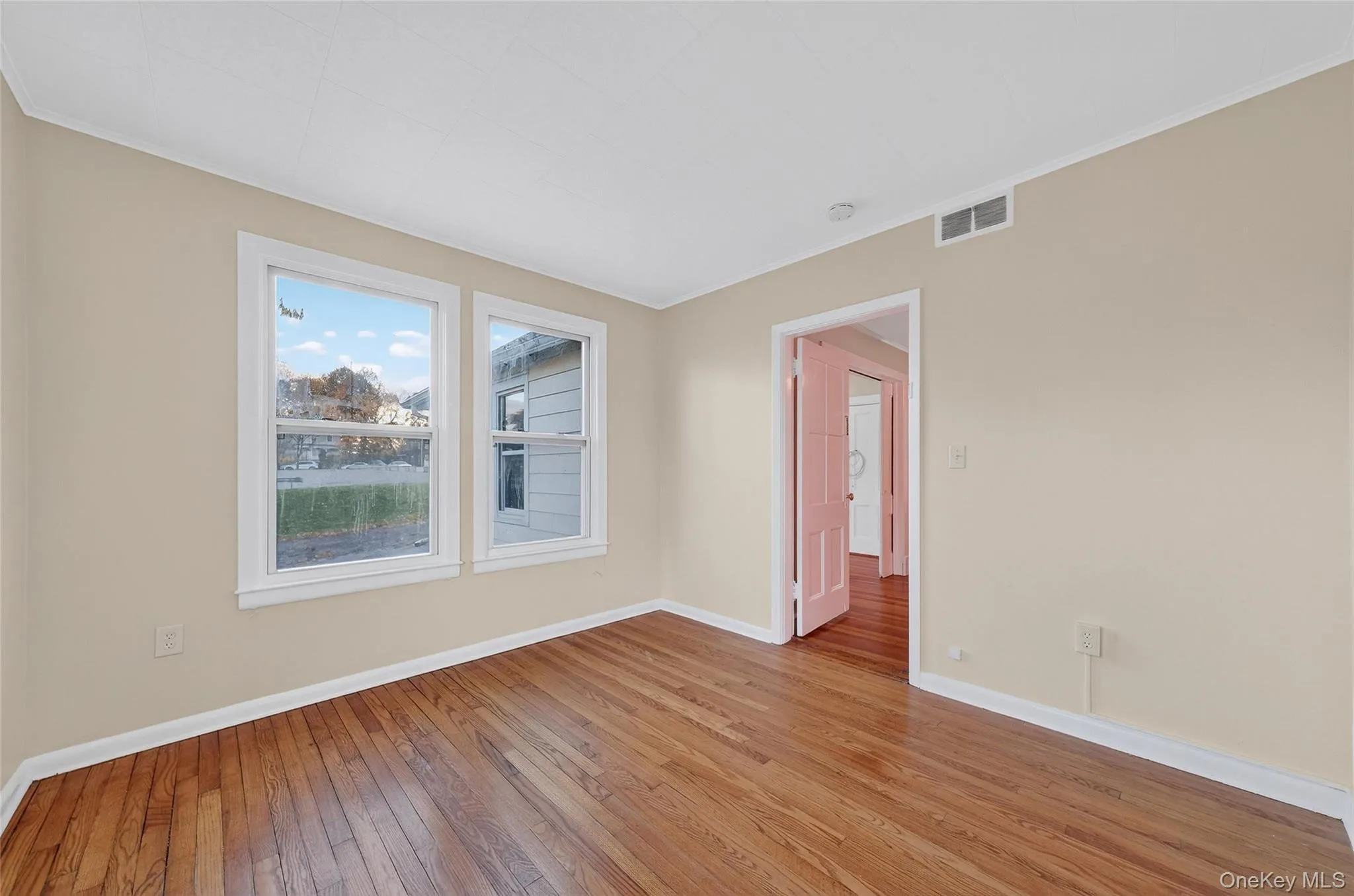 Empty room featuring hardwood / wood-style floors and crown molding Empty room featuring hardwood / wood-style floors and crown molding