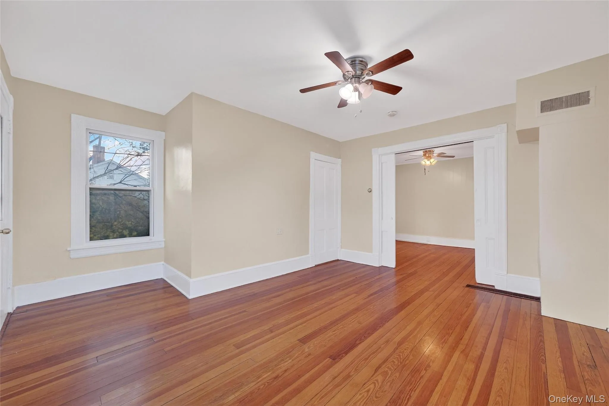 Unfurnished room featuring wood-type flooring and baseboards Unfurnished room featuring wood-type flooring and baseboards