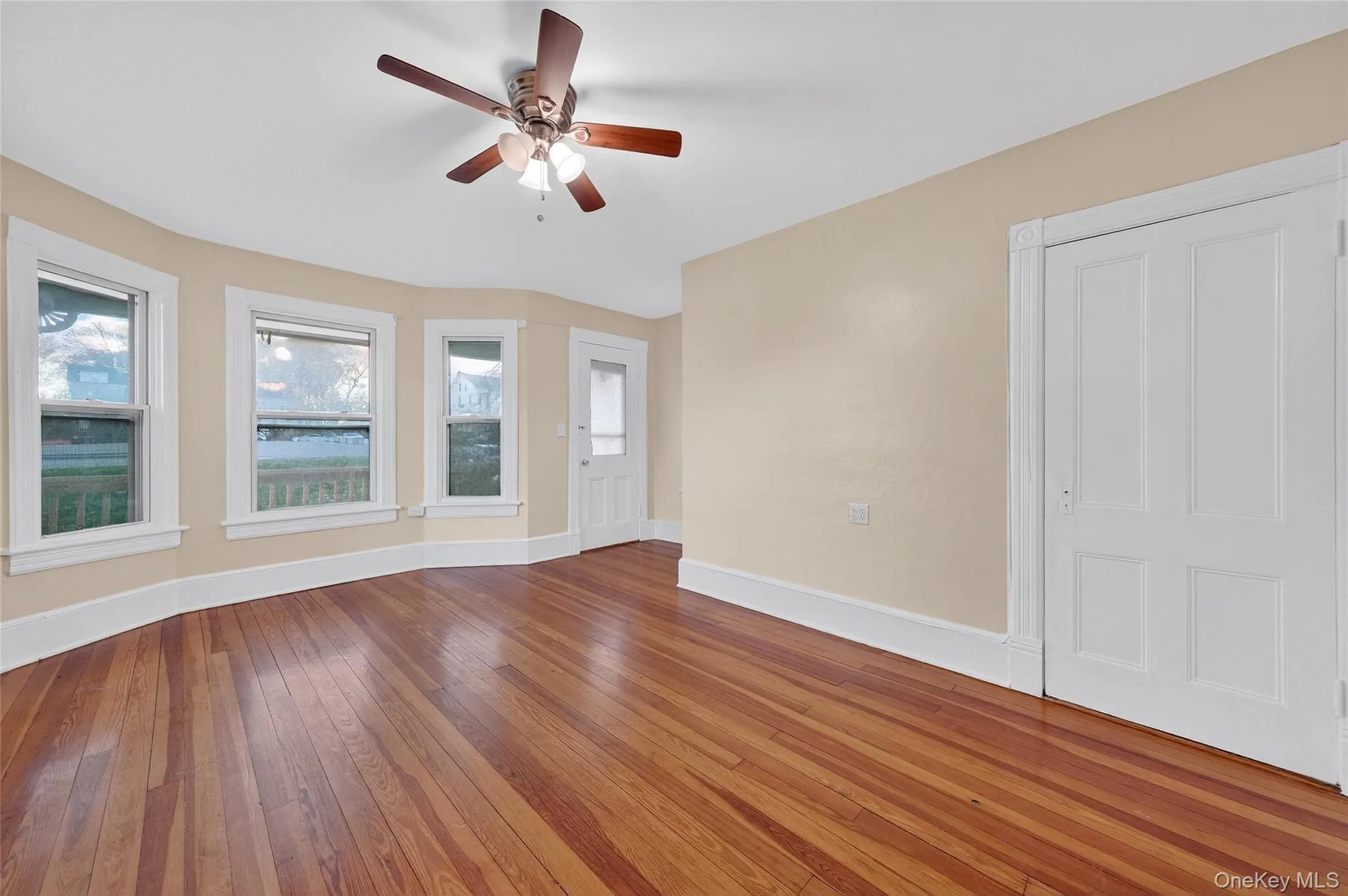 Empty room with hardwood / wood-style flooring and a ceiling fan Empty room with hardwood / wood-style flooring and a ceiling fan