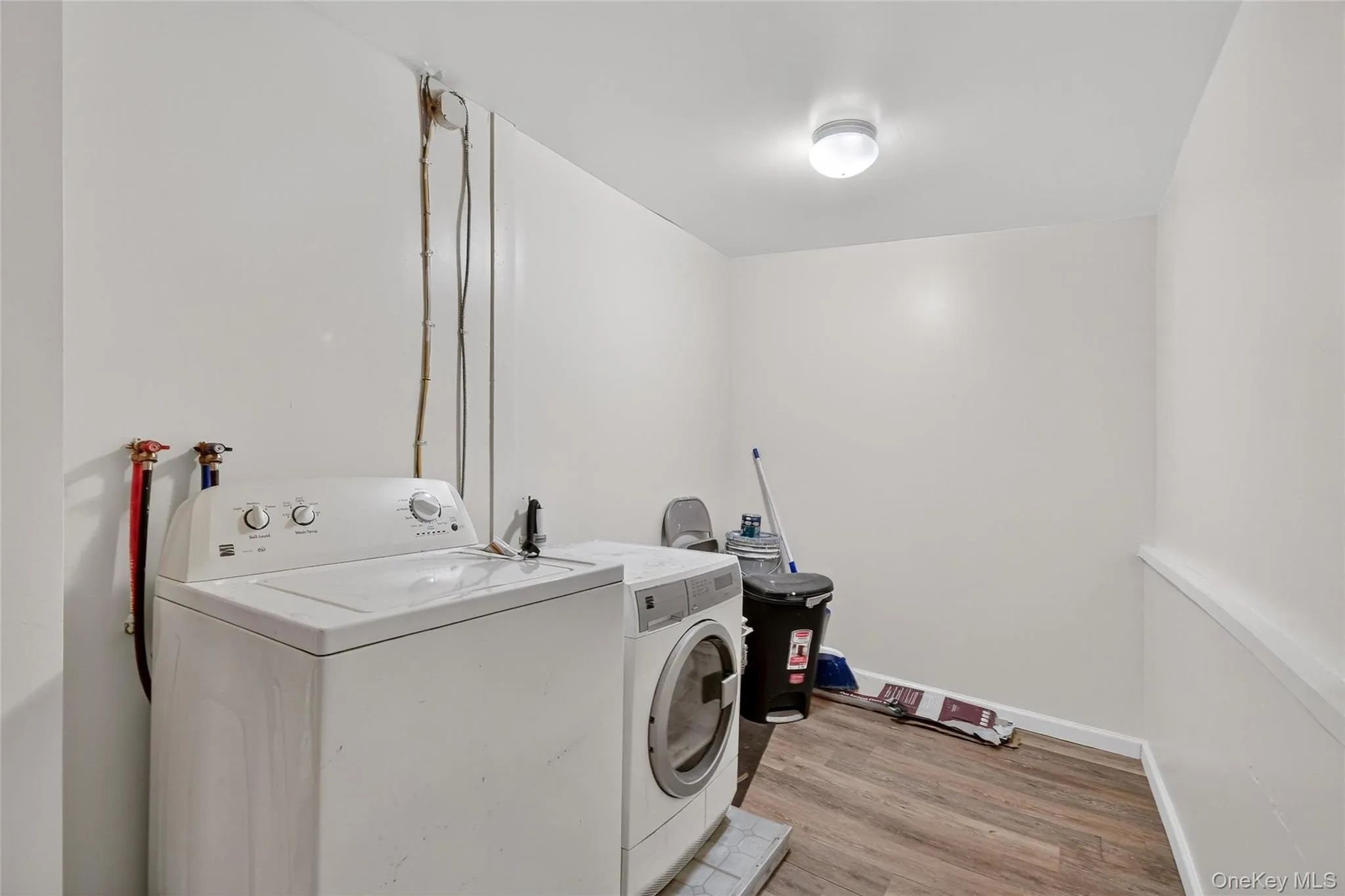 Washroom featuring light wood-style flooring and washing machine and clothes dryer Washroom featuring light wood-style flooring and washing machine and clothes dryer