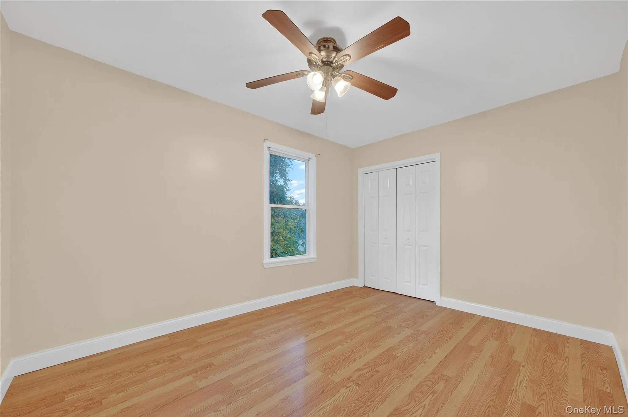 Unfurnished bedroom featuring wood finished floors, ceiling fan, and a closet Unfurnished bedroom featuring wood finished floors, ceiling fan, and a closet