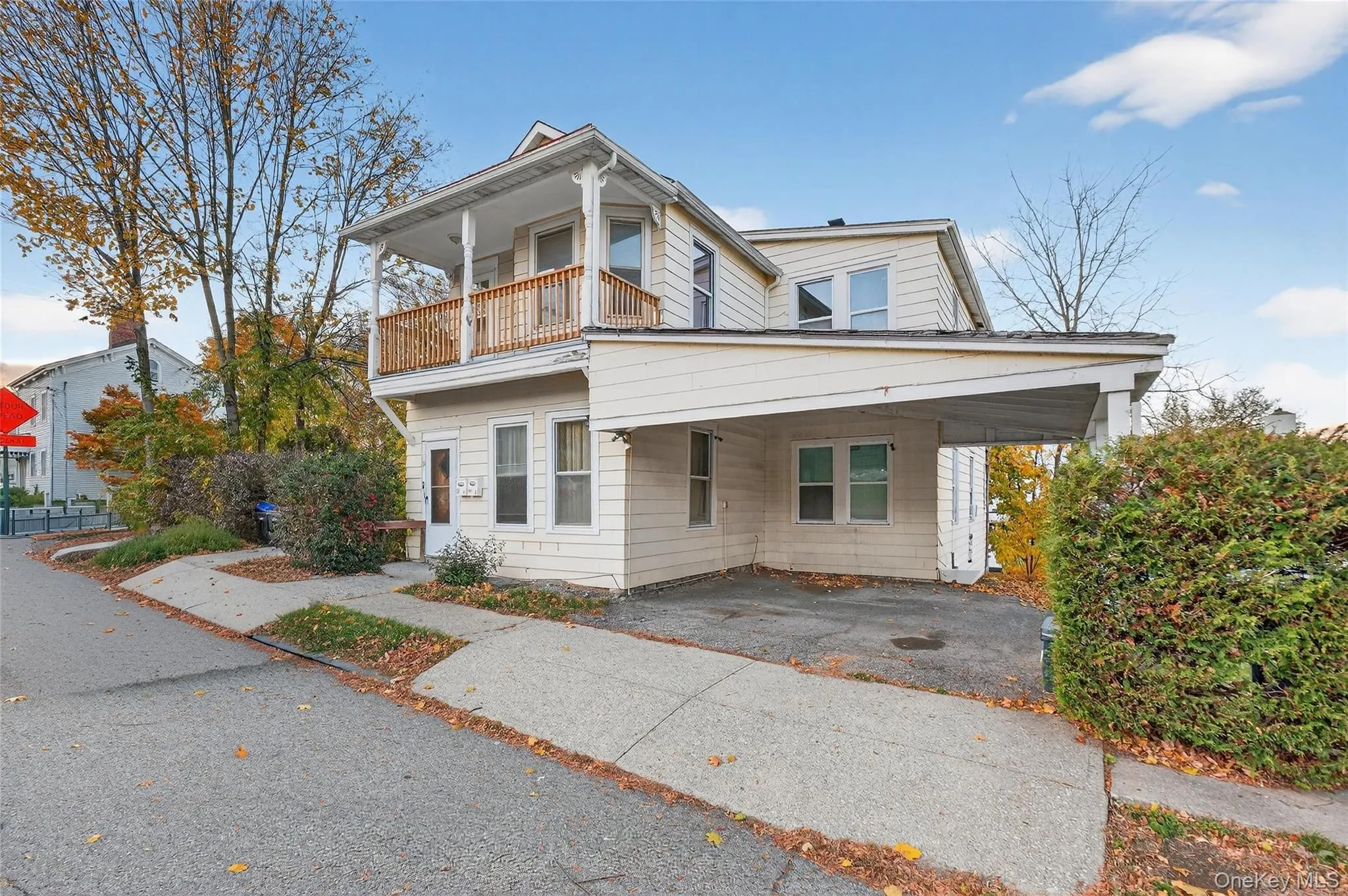 View of front of home with an attached carport, a balcony, and driveway View of front of home with an attached carport, a balcony, and driveway